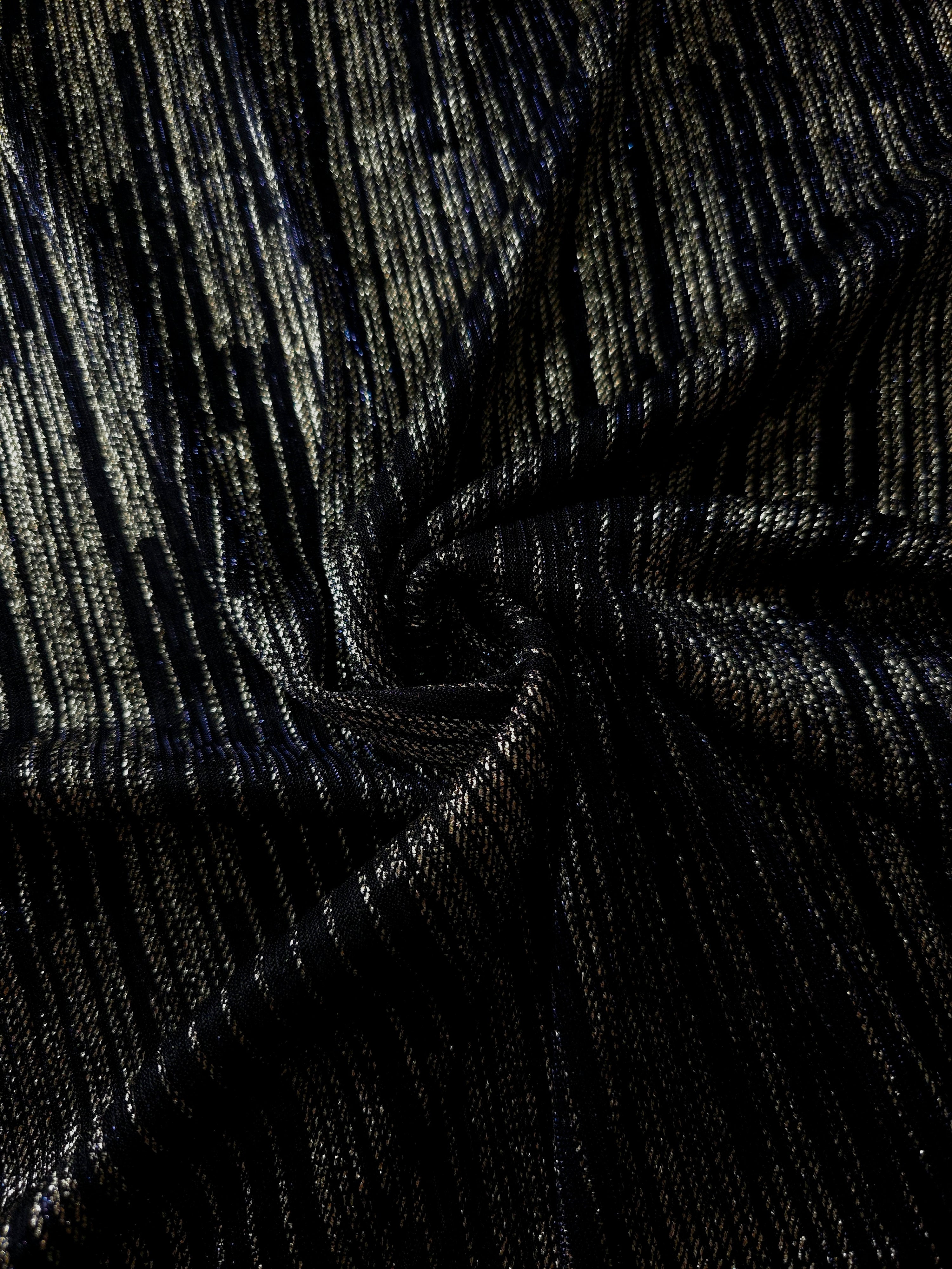 Swirl-draped Jet Black Sheer Metallic Shimmer Stretch Tulle Fabric showing fluid movement, reflective shimmer, airy transparency and flexible stretch for dresses, dancewear and stage looks