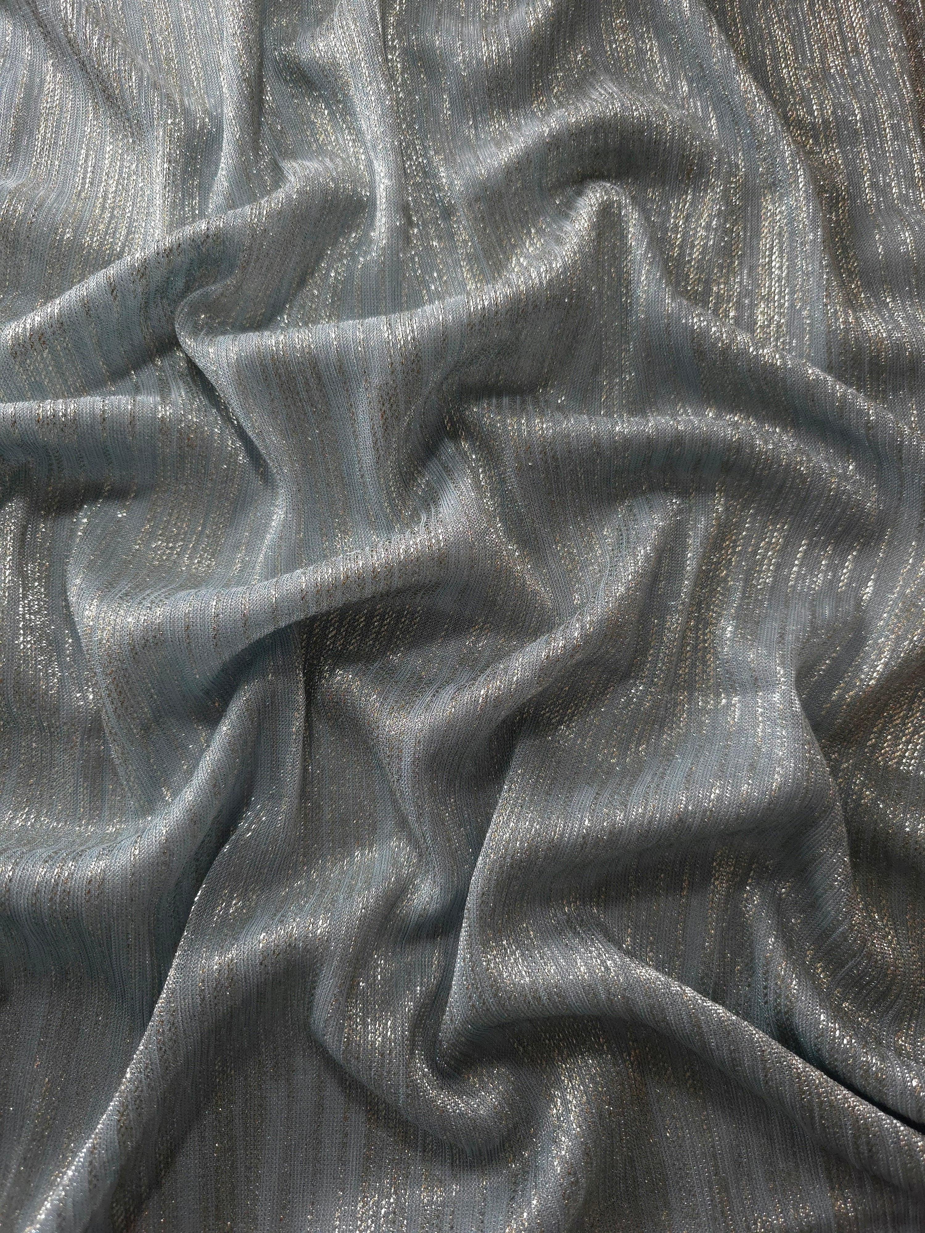 Draped Pewter Gray Sheer Metallic Shimmer Stretch Tulle Fabric showing luminous reflective folds, soft transparency and flexible flow for dresses, dancewear, stagewear and occasion looks