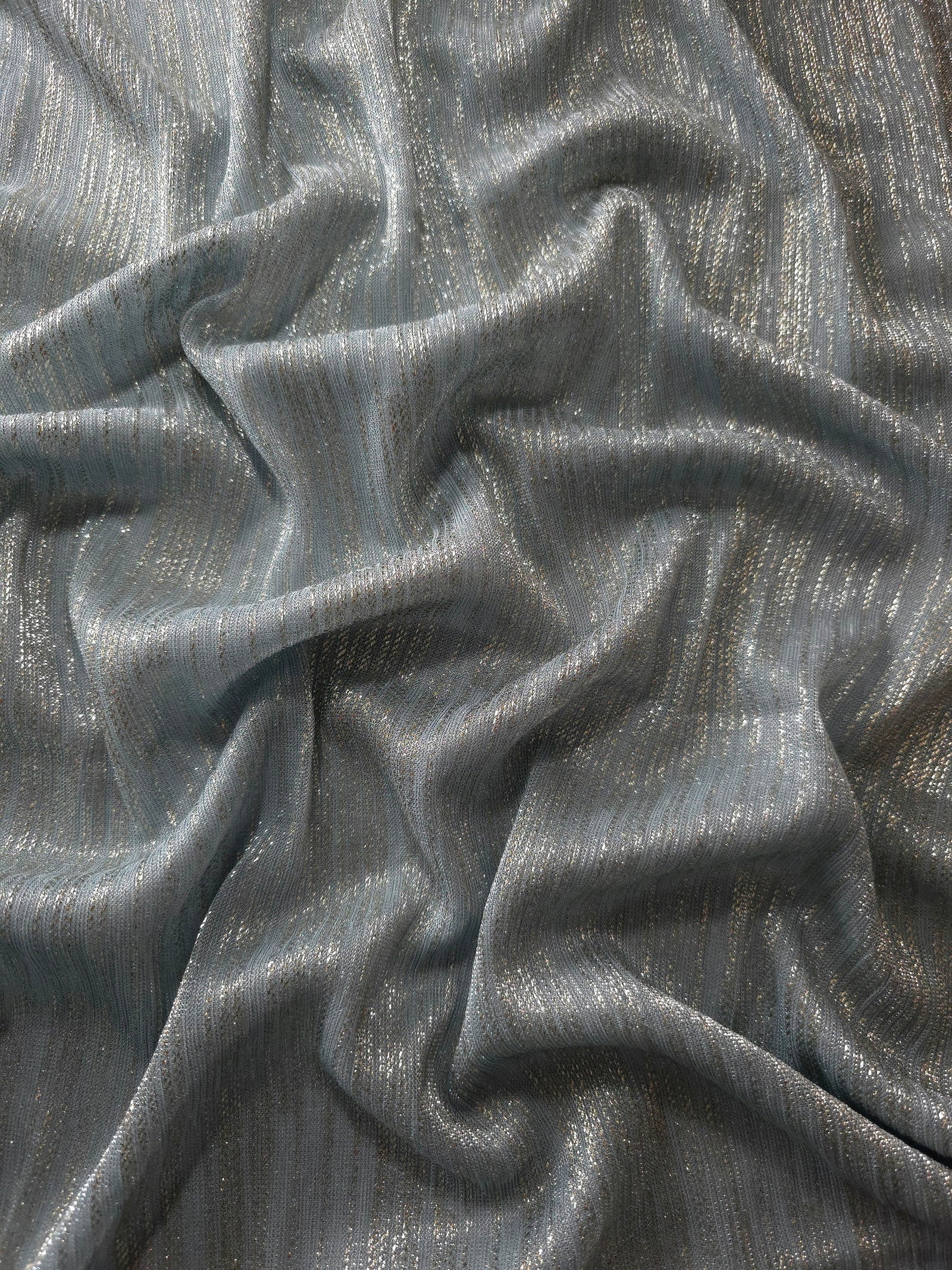 Draped Pewter Gray Sheer Metallic Shimmer Stretch Tulle Fabric showing luminous reflective folds, soft transparency and flexible flow for dresses, dancewear, stagewear and occasion looks