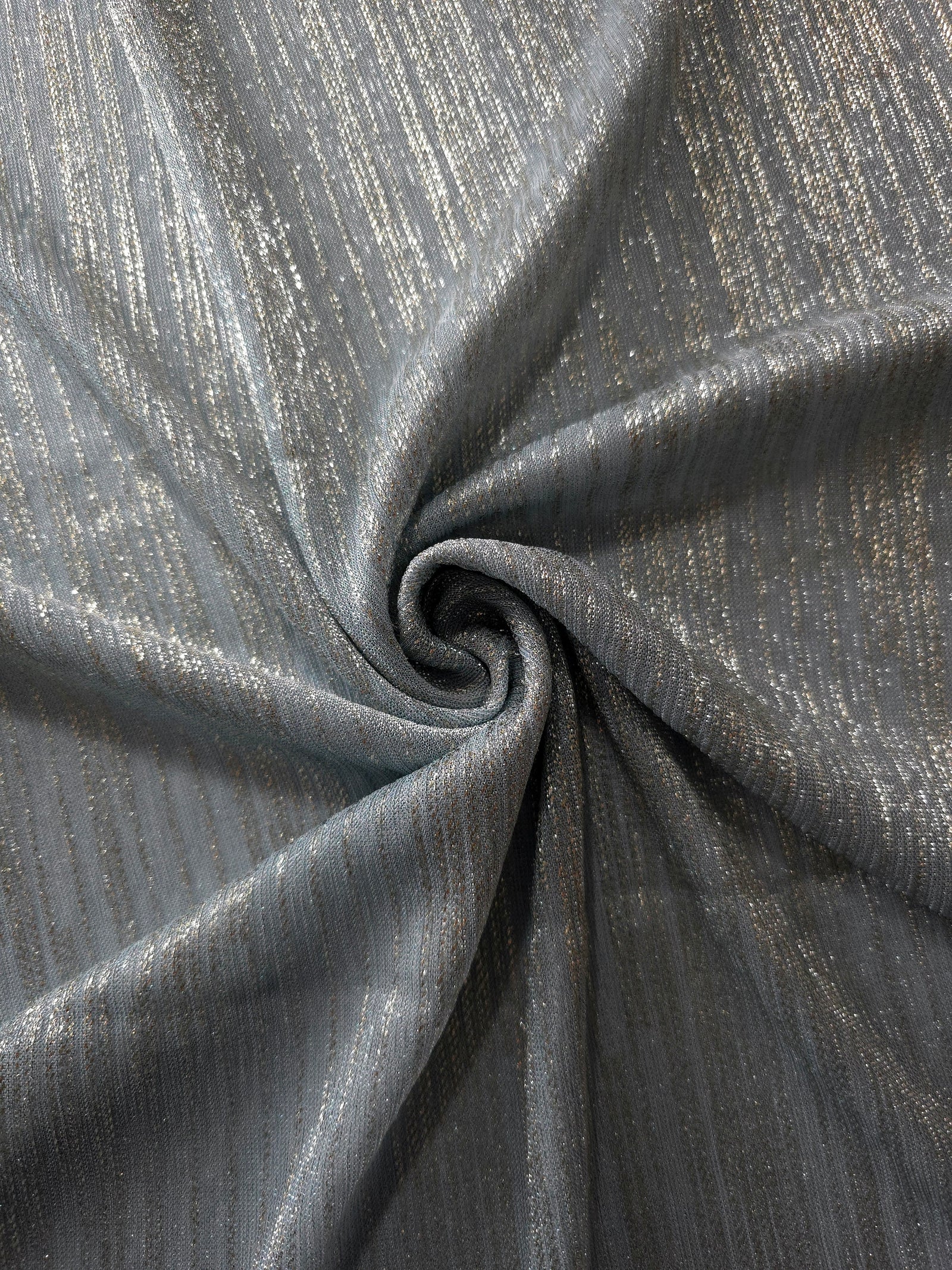 Swirl-draped Pewter Gray Sheer Metallic Shimmer Stretch Tulle Fabric showing fluid movement, reflective shimmer, airy transparency and flexible stretch for dresses, dancewear and stage looks