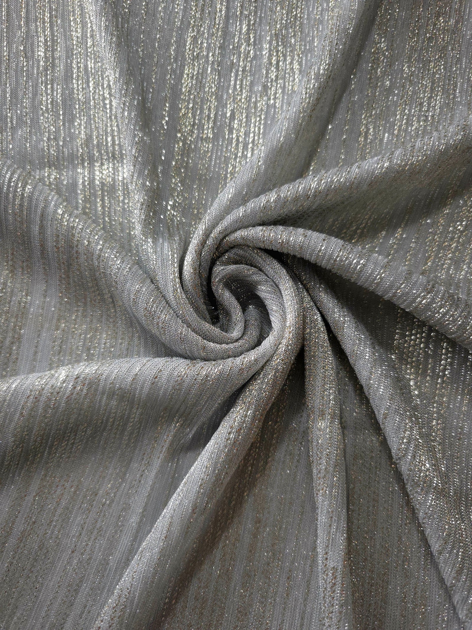 Swirl-draped Silver Gray Sheer Metallic Shimmer Stretch Tulle Fabric showing fluid movement, reflective shimmer, airy transparency and flexible stretch for dresses, dancewear and stage looks