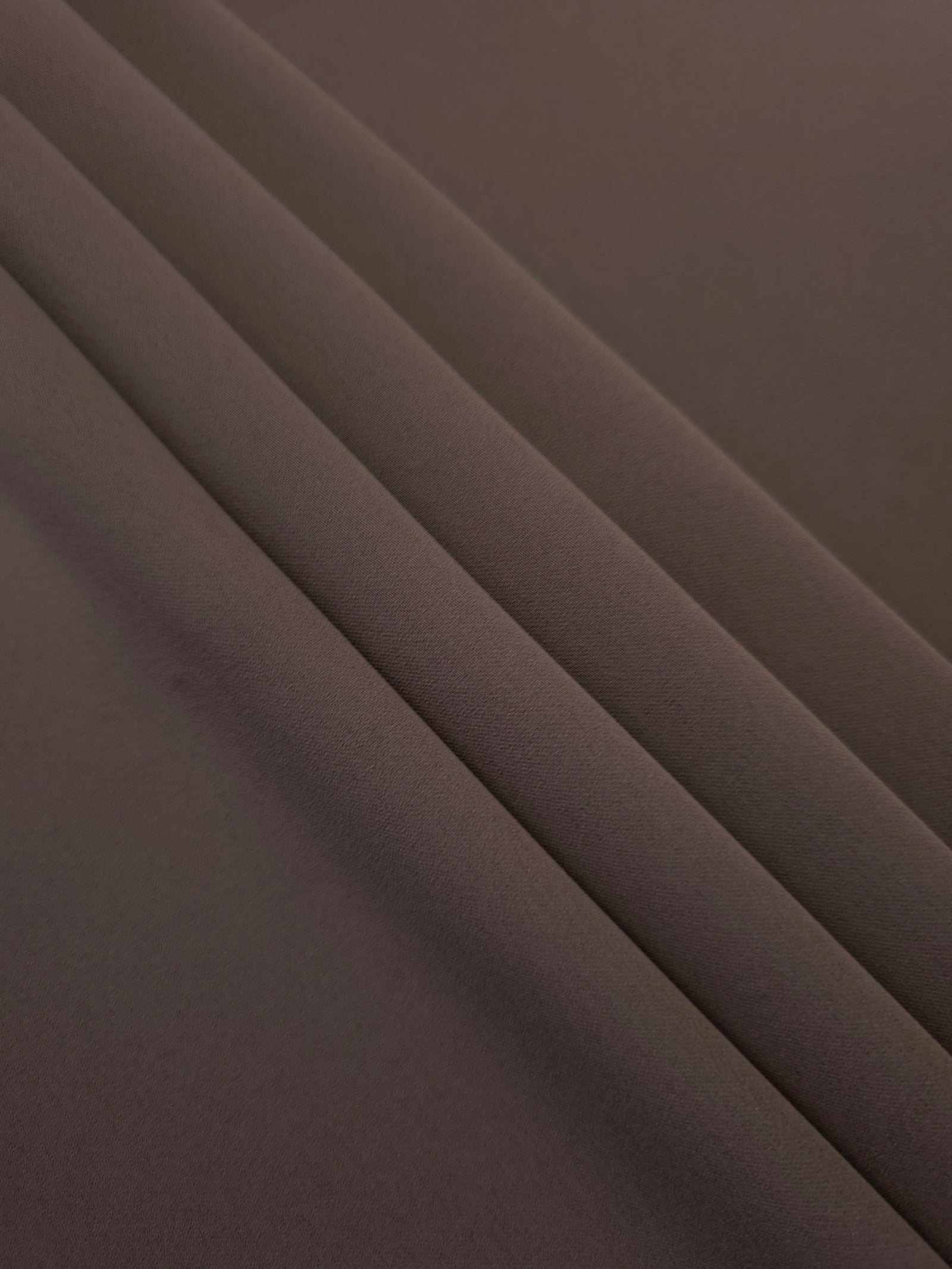 Layered Dark Cocoa Taupe polyester crepe showing soft body and slight mechanical stretch for light tailoring