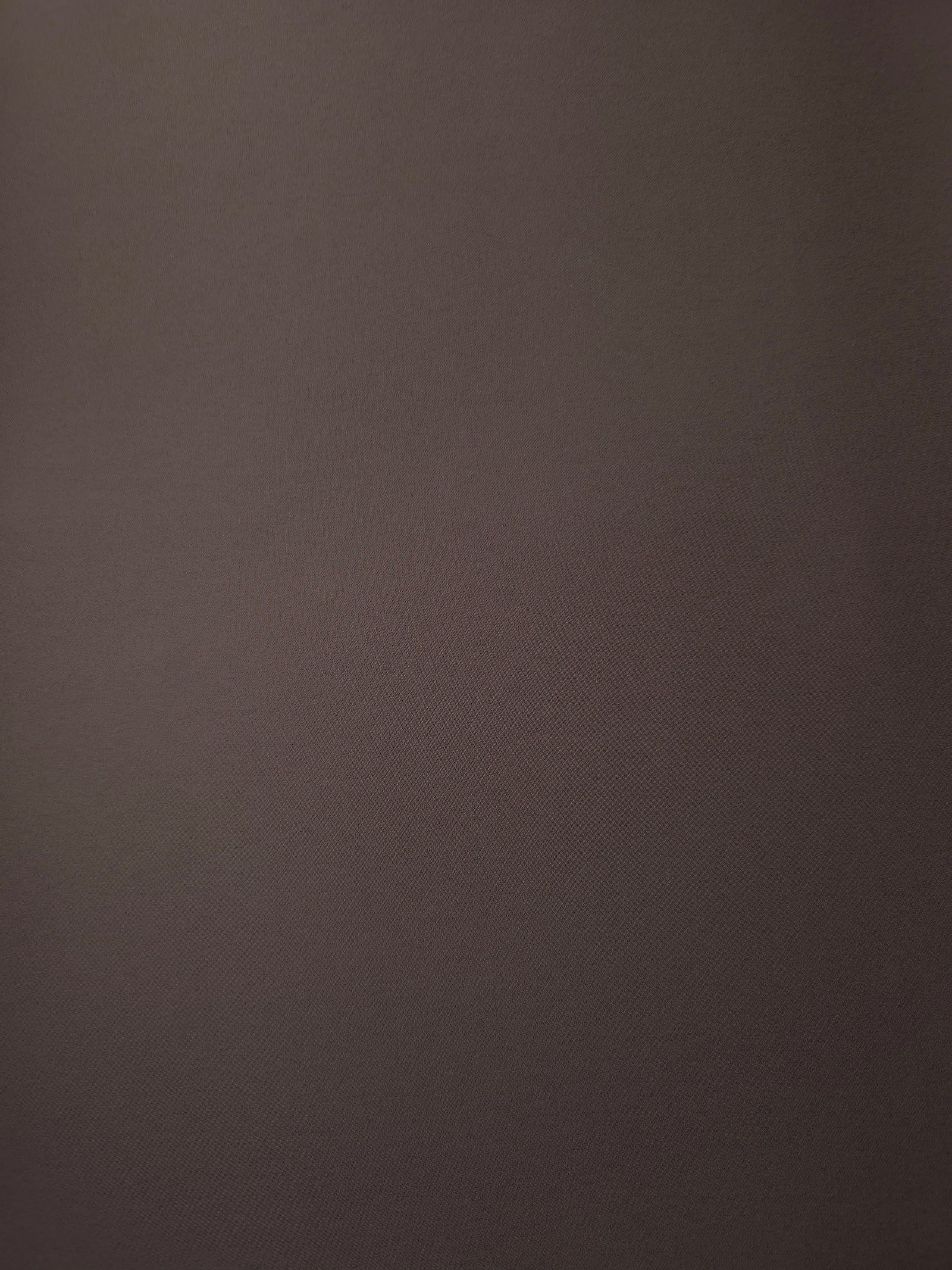 Flat surface of Dark Cocoa Taupe Korean crepe, a 205 GSM opaque polyester fabric with smooth dressmaking character