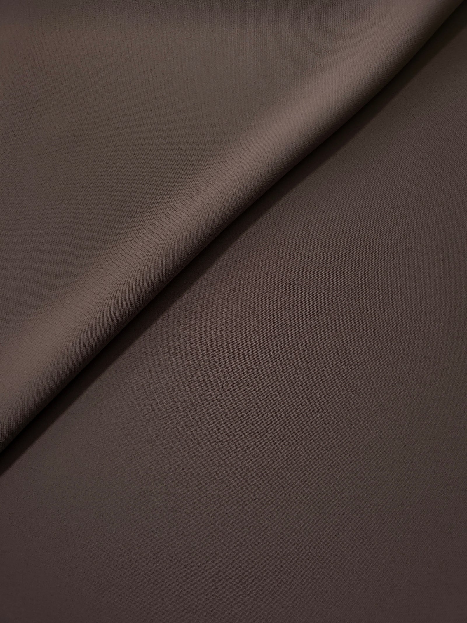 Soft-fold view of Dark Cocoa Taupe Korean polyester crepe showing fluid drape for blouses, skirts and dresses