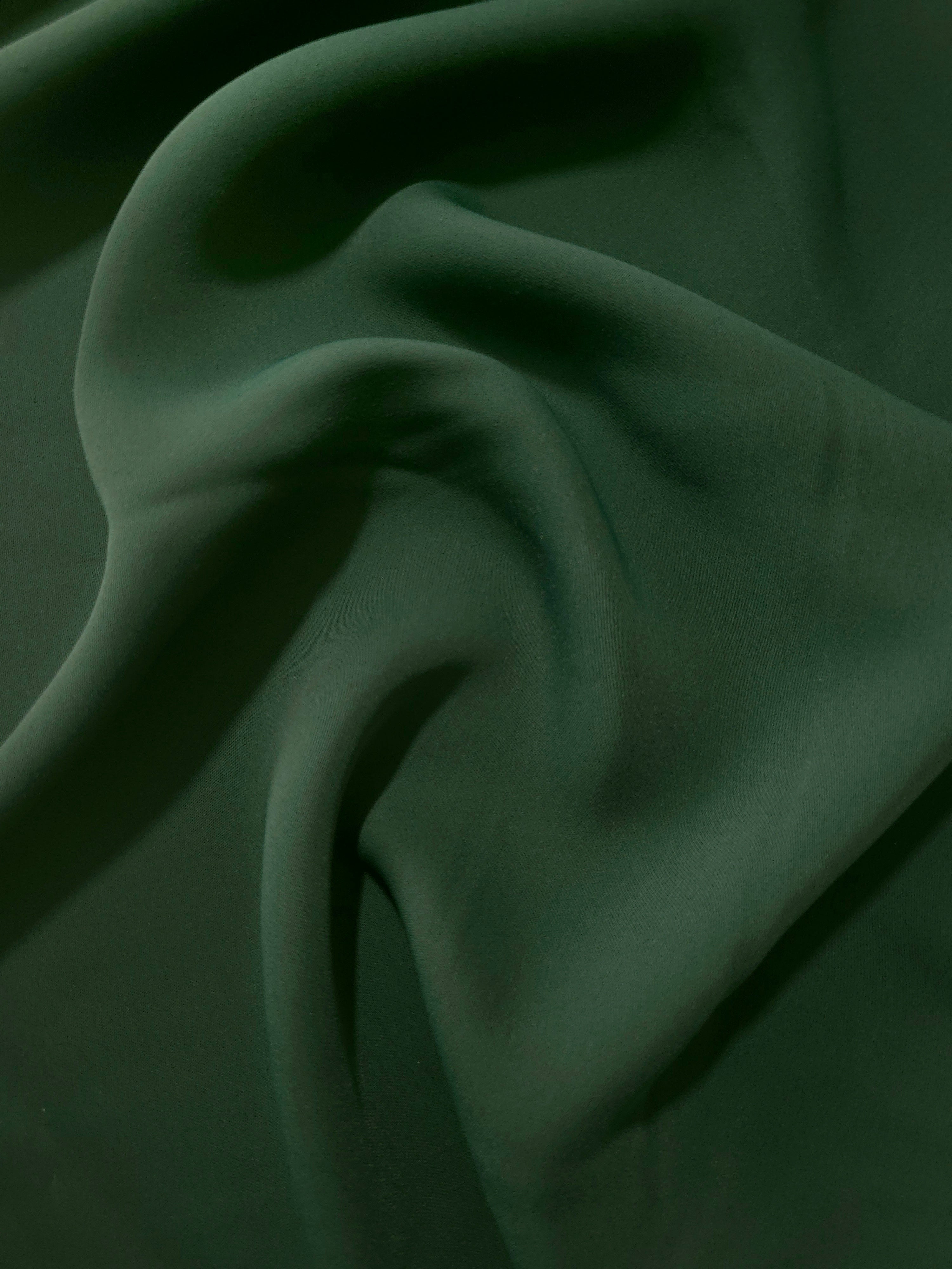 Fluid folds of Dark Hunter Green polyester crepe, a flowing apparel fabric suited to eveningwear and skirts