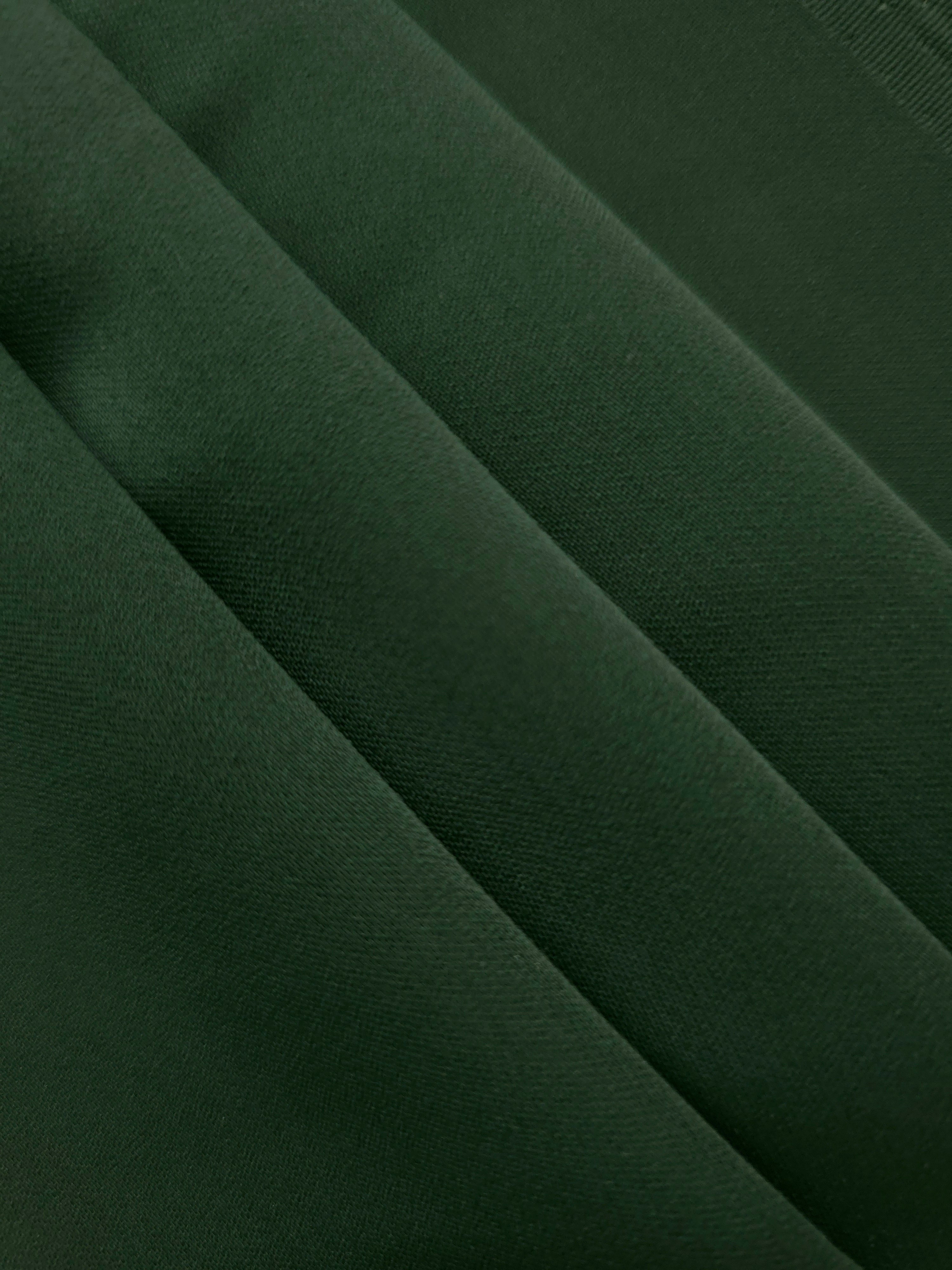 Layered folds of Dark Hunter Green mechanical polyester crepe showing soft structure and gentle construction stretch