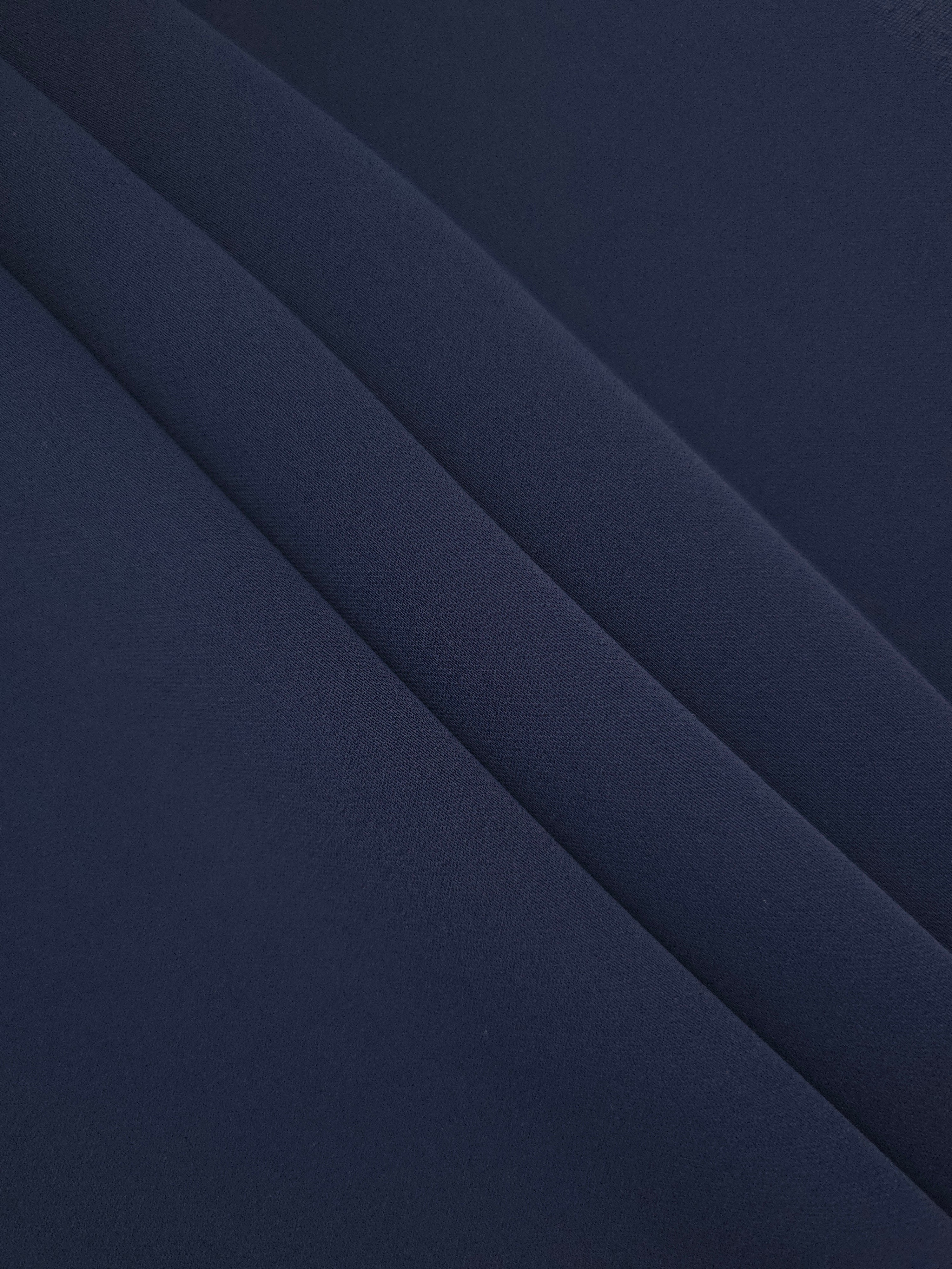 Stacked folds of Dark Navy Blue mechanical polyester crepe showing soft structure and gentle stretch for apparel