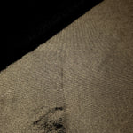 Dark Olive Taupe metallic stretch fabric in a soft fold, revealing reflective drape for dancewear, dresses and statement apparel