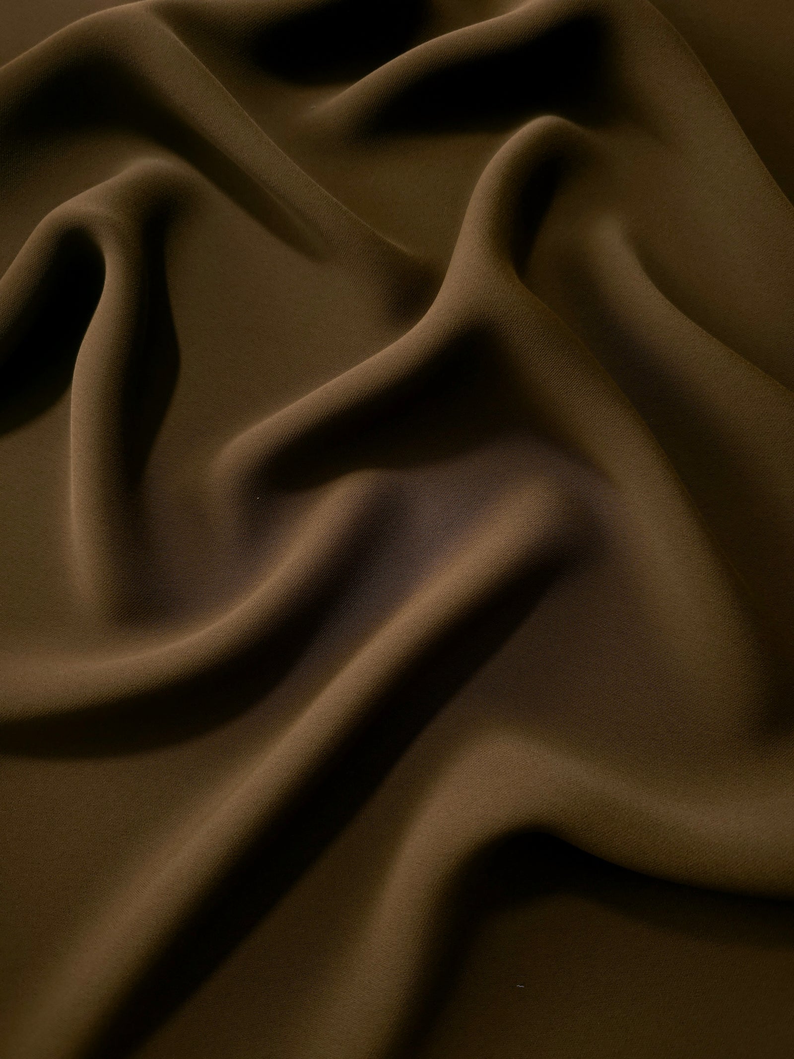 Dark Walnut Brown polyester crepe in long draped folds, showing flowing coverage for abayas and modest fashion
