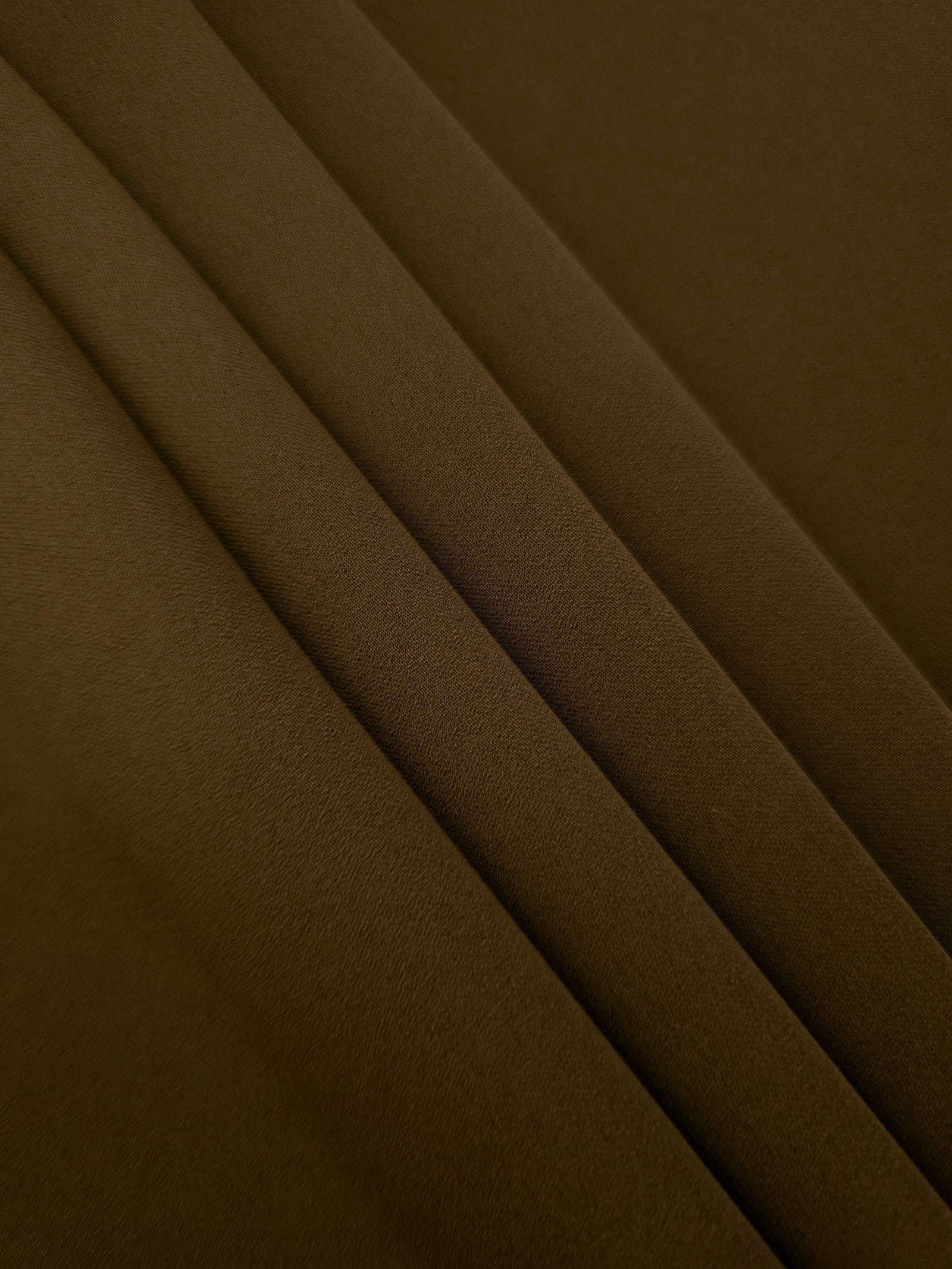 Dark Walnut Brown Korean crepe in layered folds, showing soft structure and slight mechanical stretch for skirts
