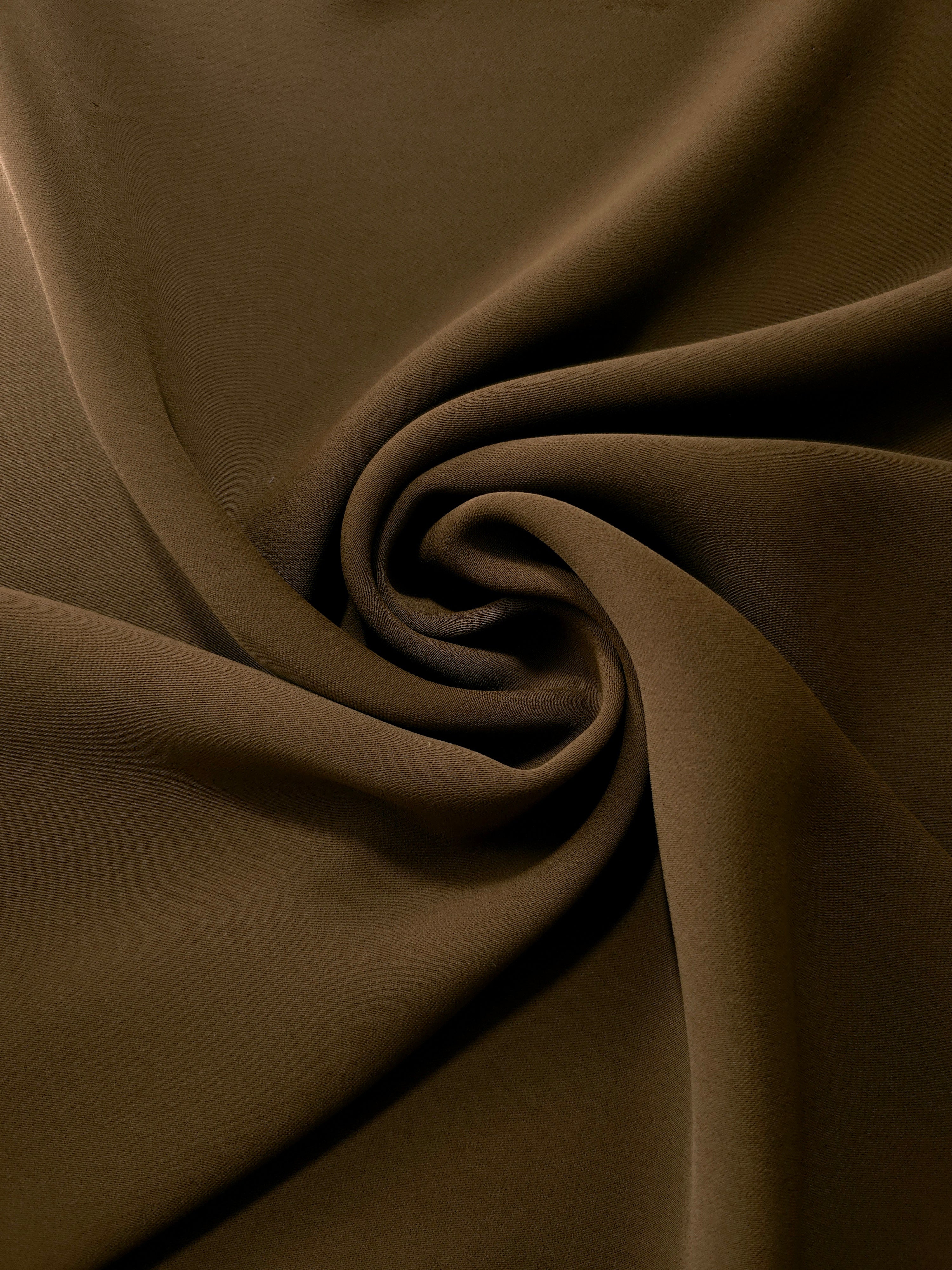 Swirled Dark Walnut Brown Korean crepe showing fluid movement and silky drape for dresses and occasionwear