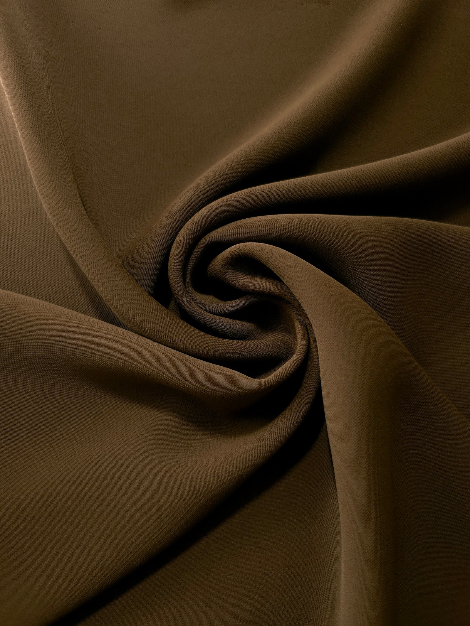 Swirled Dark Walnut Brown Korean crepe showing fluid movement and silky drape for dresses and occasionwear