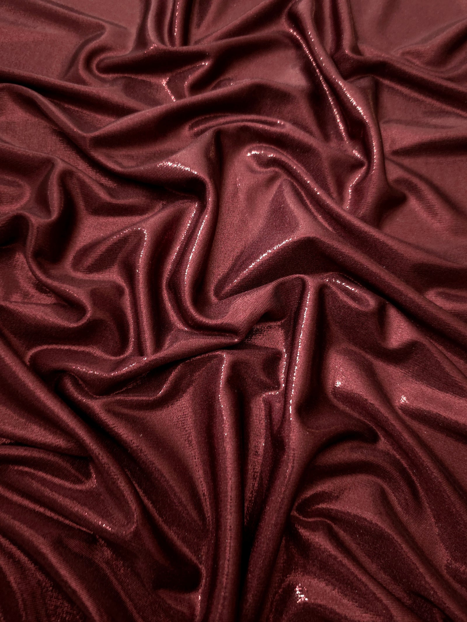 Draped Deep Burgundy shimmer spandex fabric with luminous foil reflection, suited to gowns, skirts and theatrical apparel