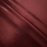 Deep Burgundy shimmer spandex fabric stacked in soft layers, revealing metallic reflection for costumes, dresses and creative apparel