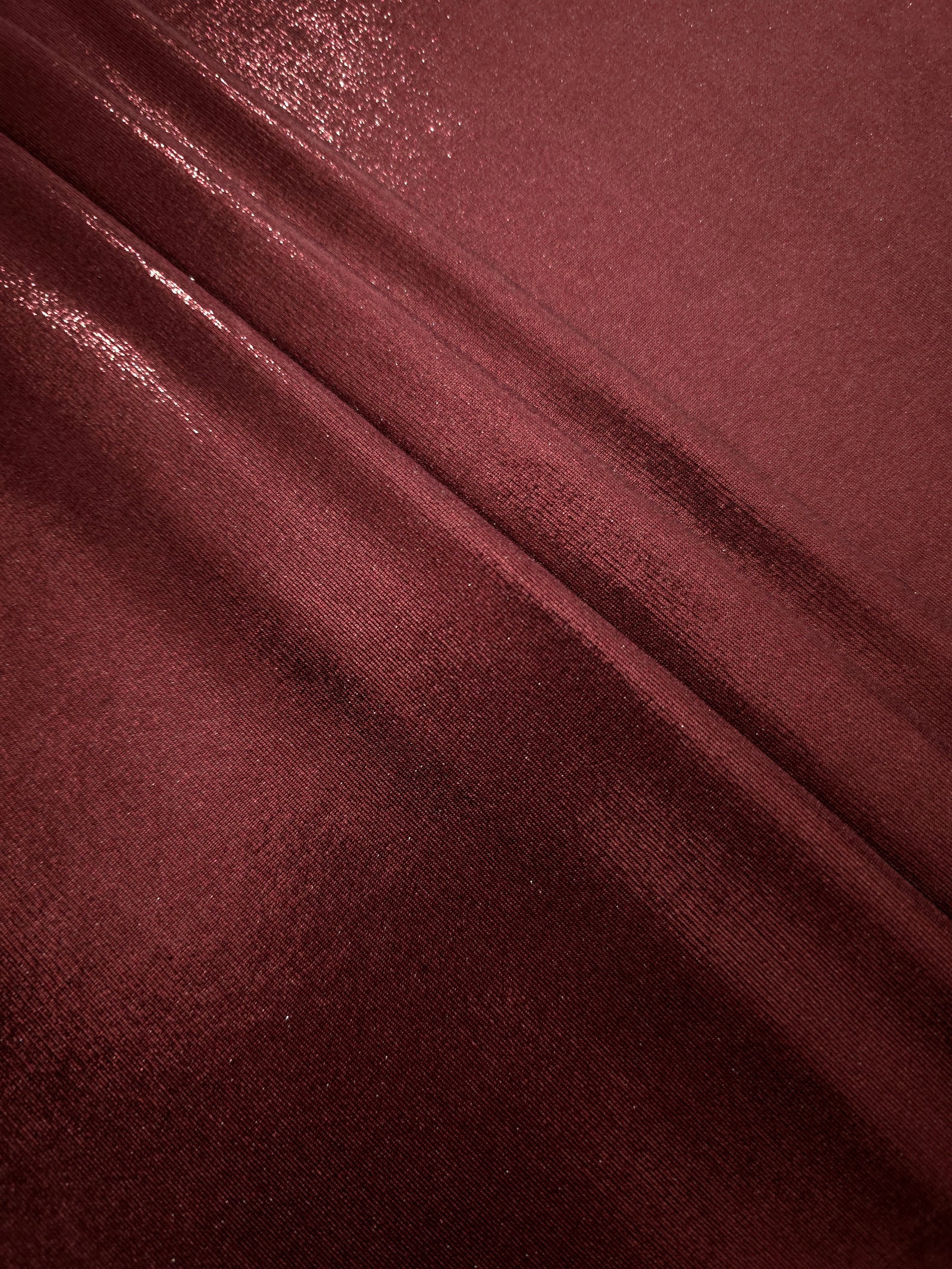 Deep Burgundy shimmer spandex fabric stacked in soft layers, revealing metallic reflection for costumes, dresses and creative apparel