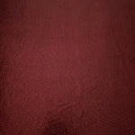 Full surface of Deep Burgundy metallic stretch fabric, highlighting luminous foil sheen for stage costumes, dresses and fashion design