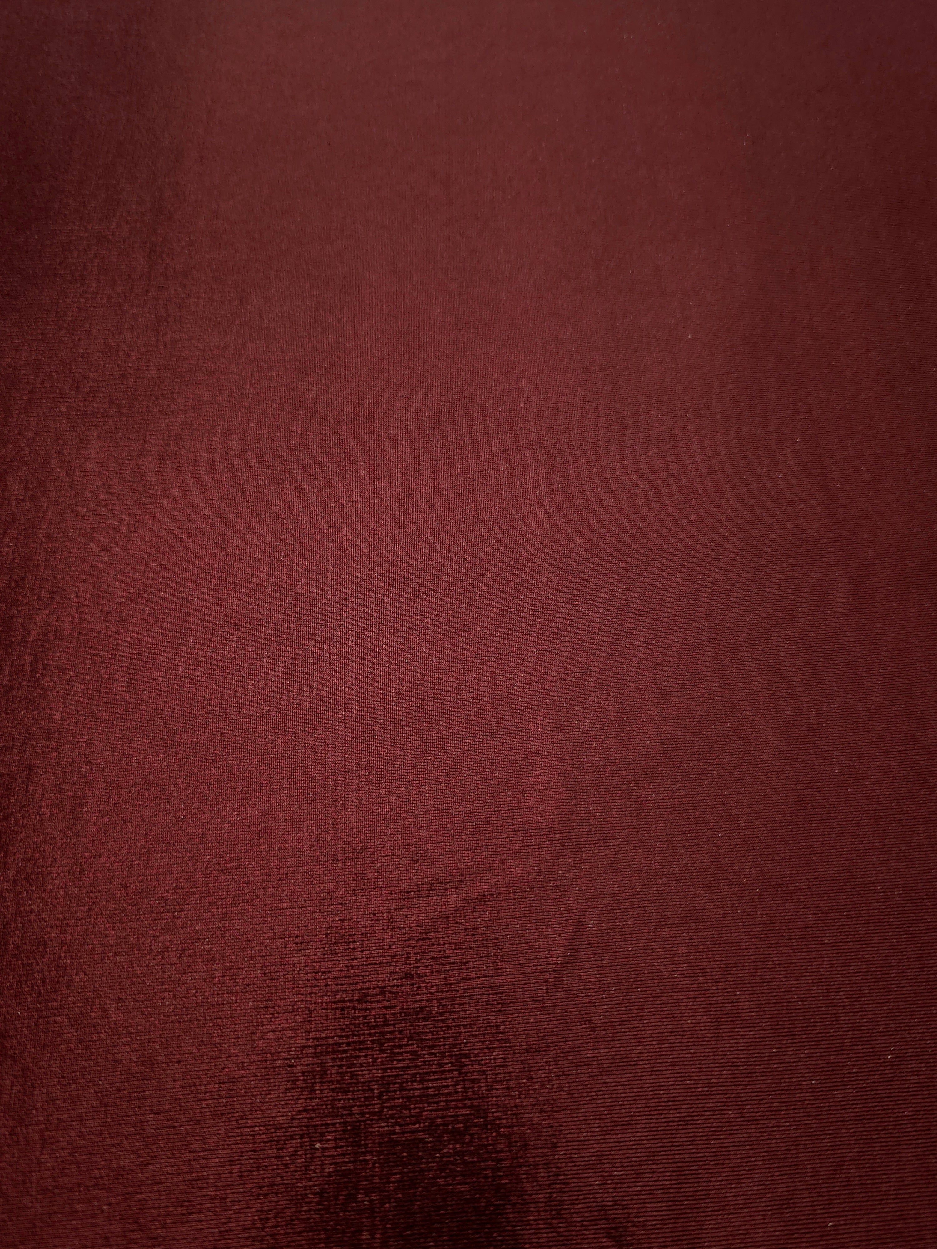 Full surface of Deep Burgundy metallic stretch fabric, highlighting luminous foil sheen for stage costumes, dresses and fashion design