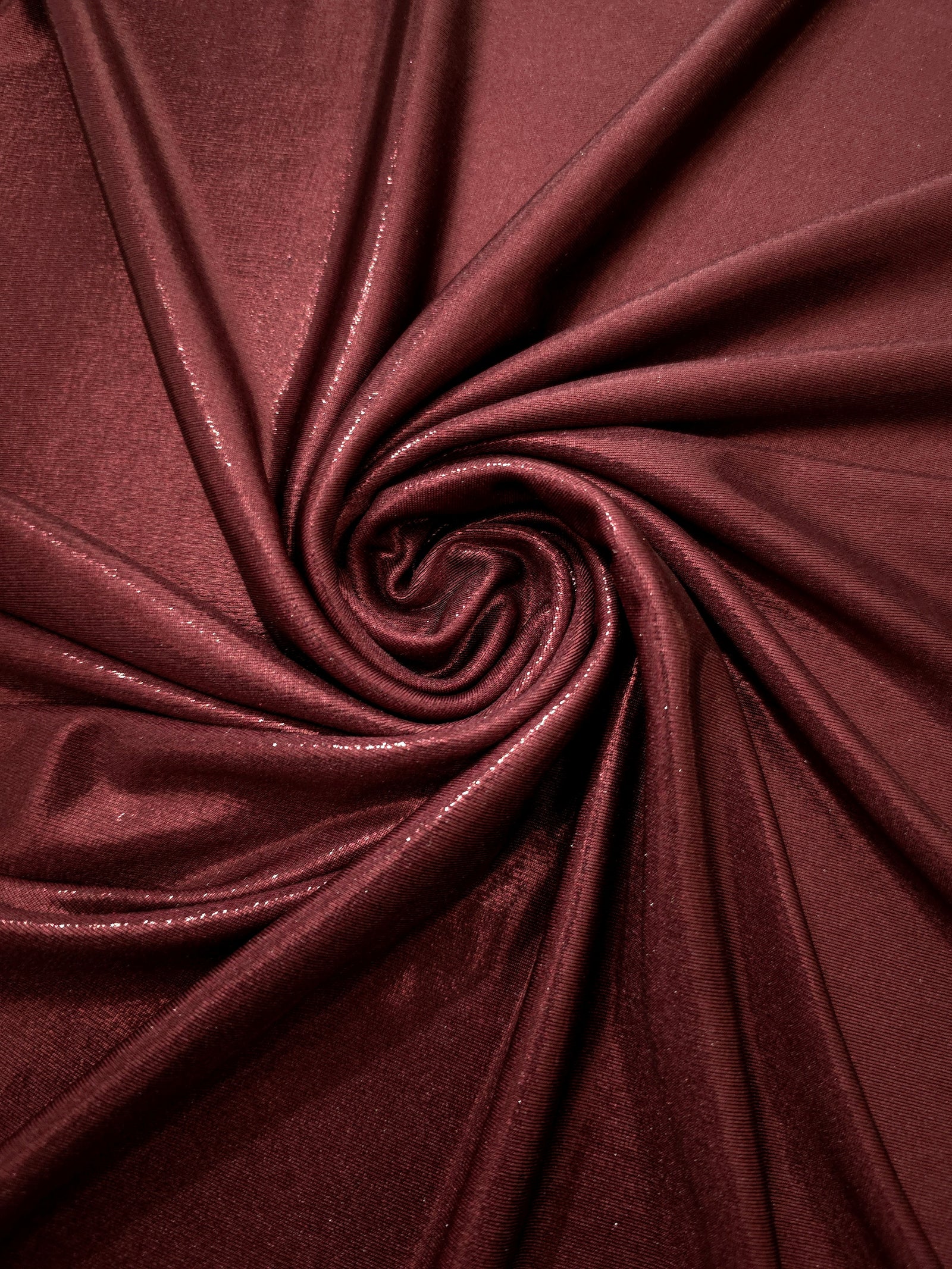 Spiraled Deep Burgundy shimmer spandex fabric showing reflective movement for evening dresses, costumes and performance apparel