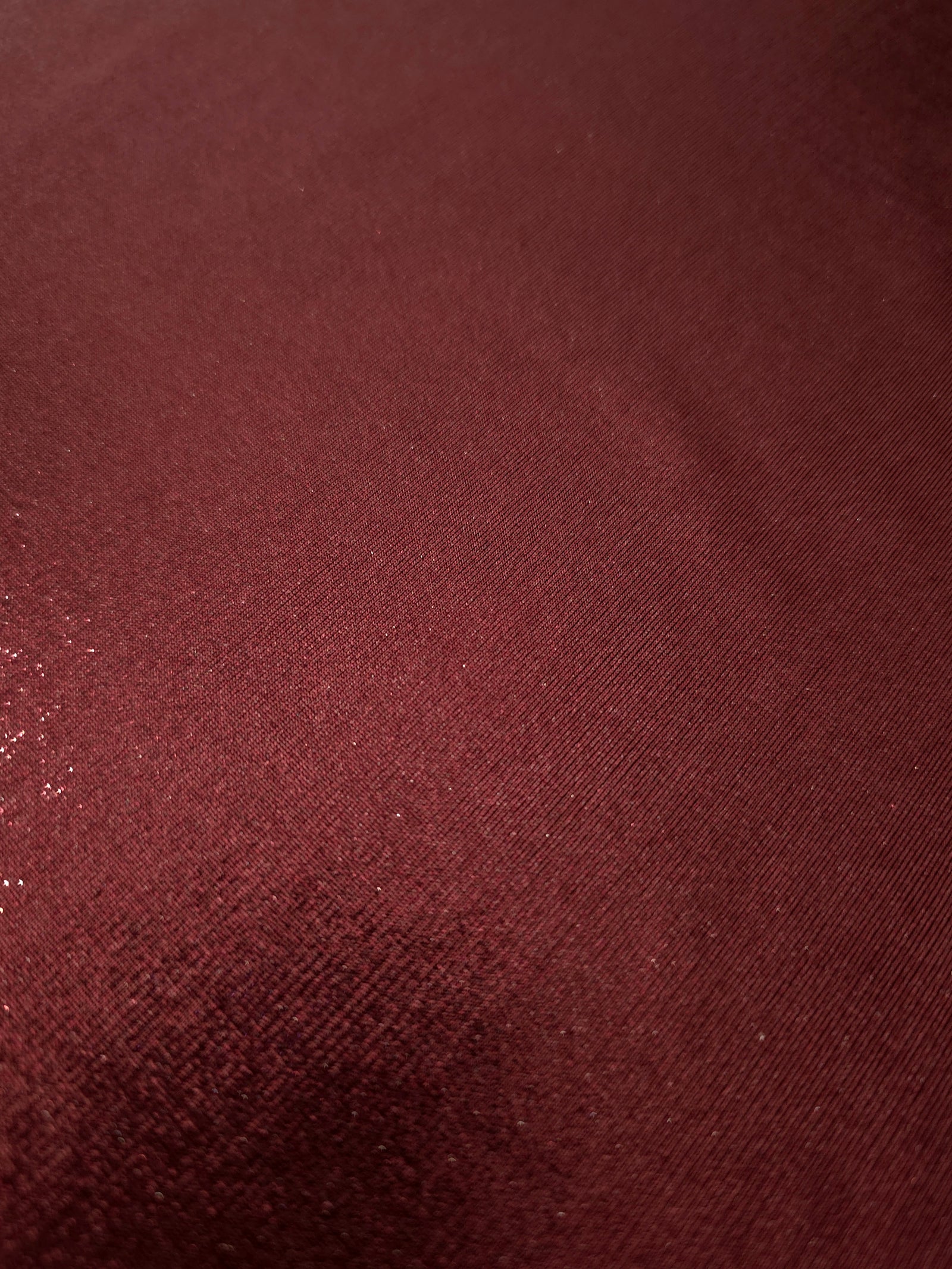 Texture view of Deep Burgundy metallic stretch fabric, highlighting foil shimmer and surface detail for performance apparel