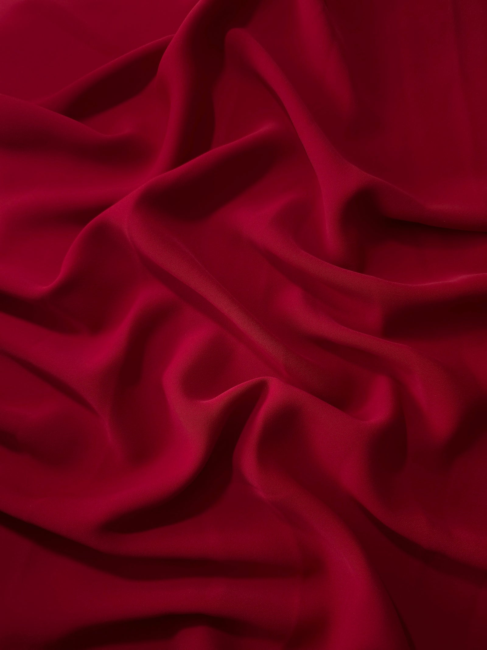 Deep Cherry Red polyester crepe in long draped folds, showing flowing coverage for abayas and modest fashion