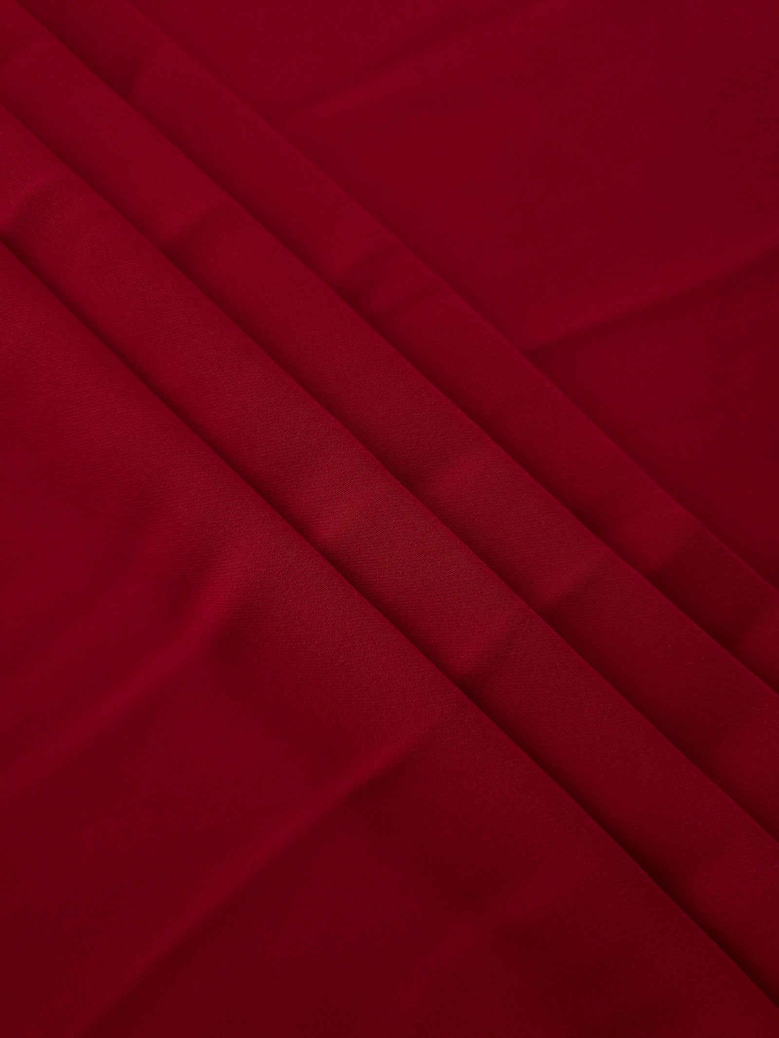 Deep Cherry Red Korean crepe in layered folds, showing soft structure and slight mechanical stretch for skirts