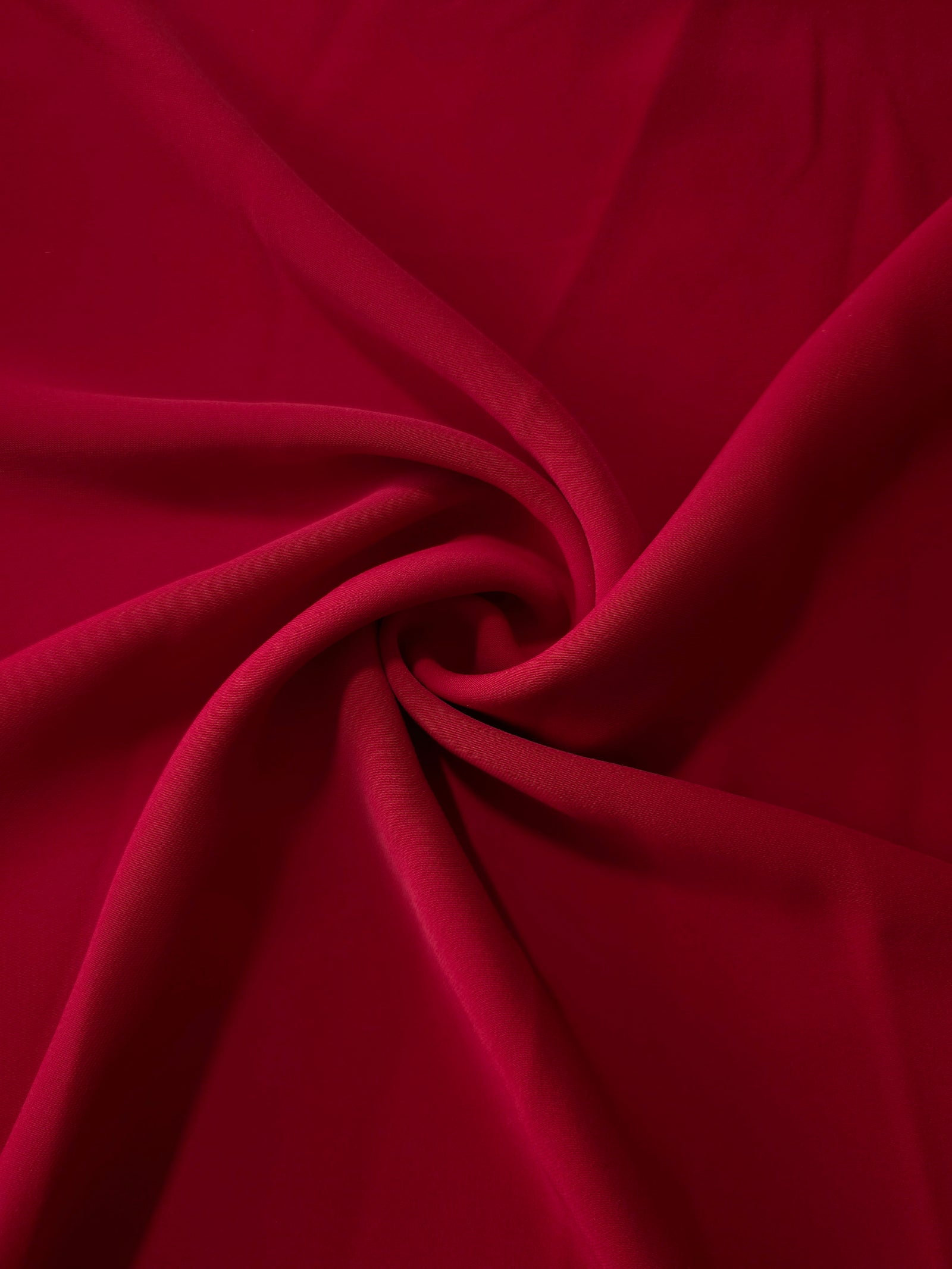 Swirled Deep Cherry Red Korean crepe showing fluid movement and silky drape for dresses and occasionwear