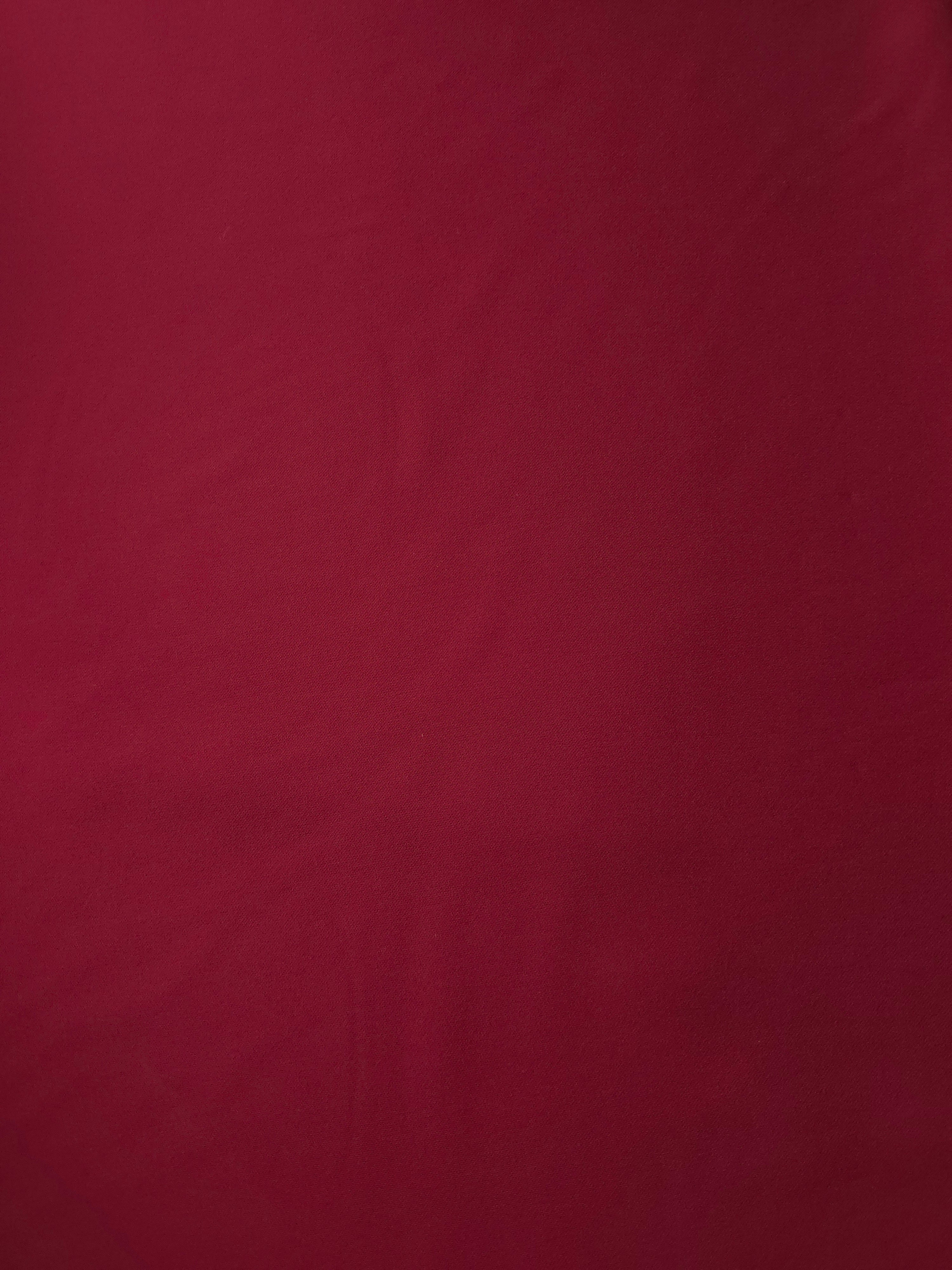 Flat surface of Deep Cranberry Red Italian polyester crepe, smooth apparel fabric for dresses and separates