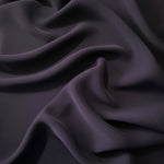 Deep Eggplant Purple Korean polyester dress fabric shown in draped folds for occasionwear, blouses and dresses