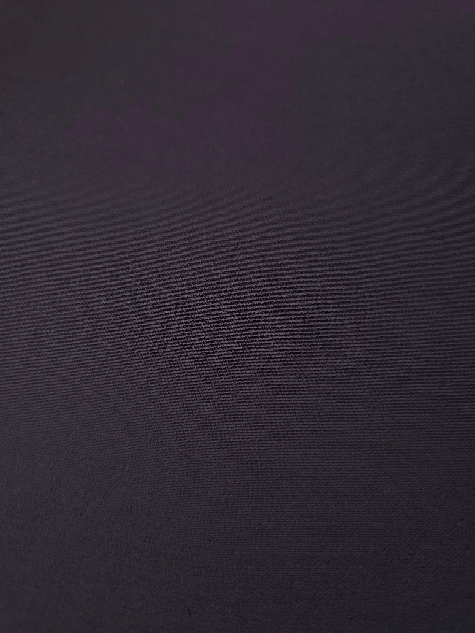 Close woven detail of Deep Eggplant Purple 100% polyester Korean crepe showing its smooth texture and soft finish