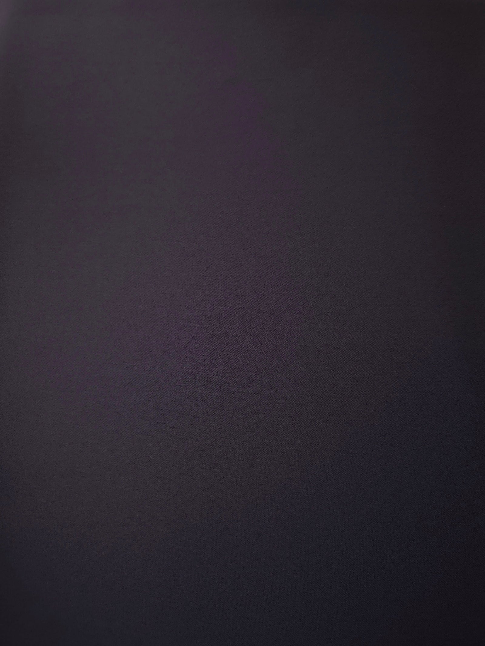 Surface view of Deep Eggplant Purple 205 GSM polyester crepe, opaque Korean dress fabric with a smooth woven finish