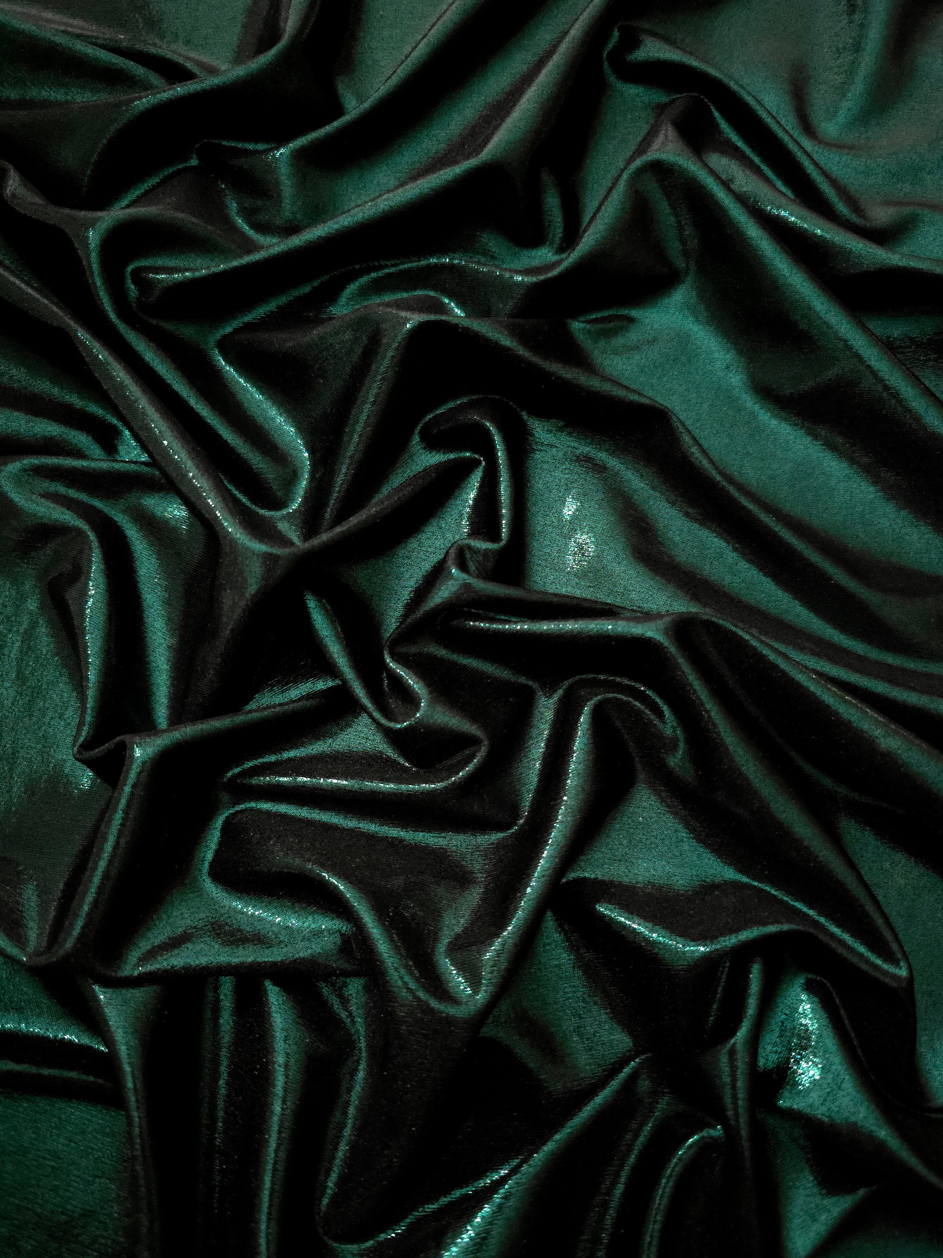 Deep Emerald Green shimmer stretch fabric in draped folds, highlighting metallic foil sheen for evening dresses, costumes and statement apparel
