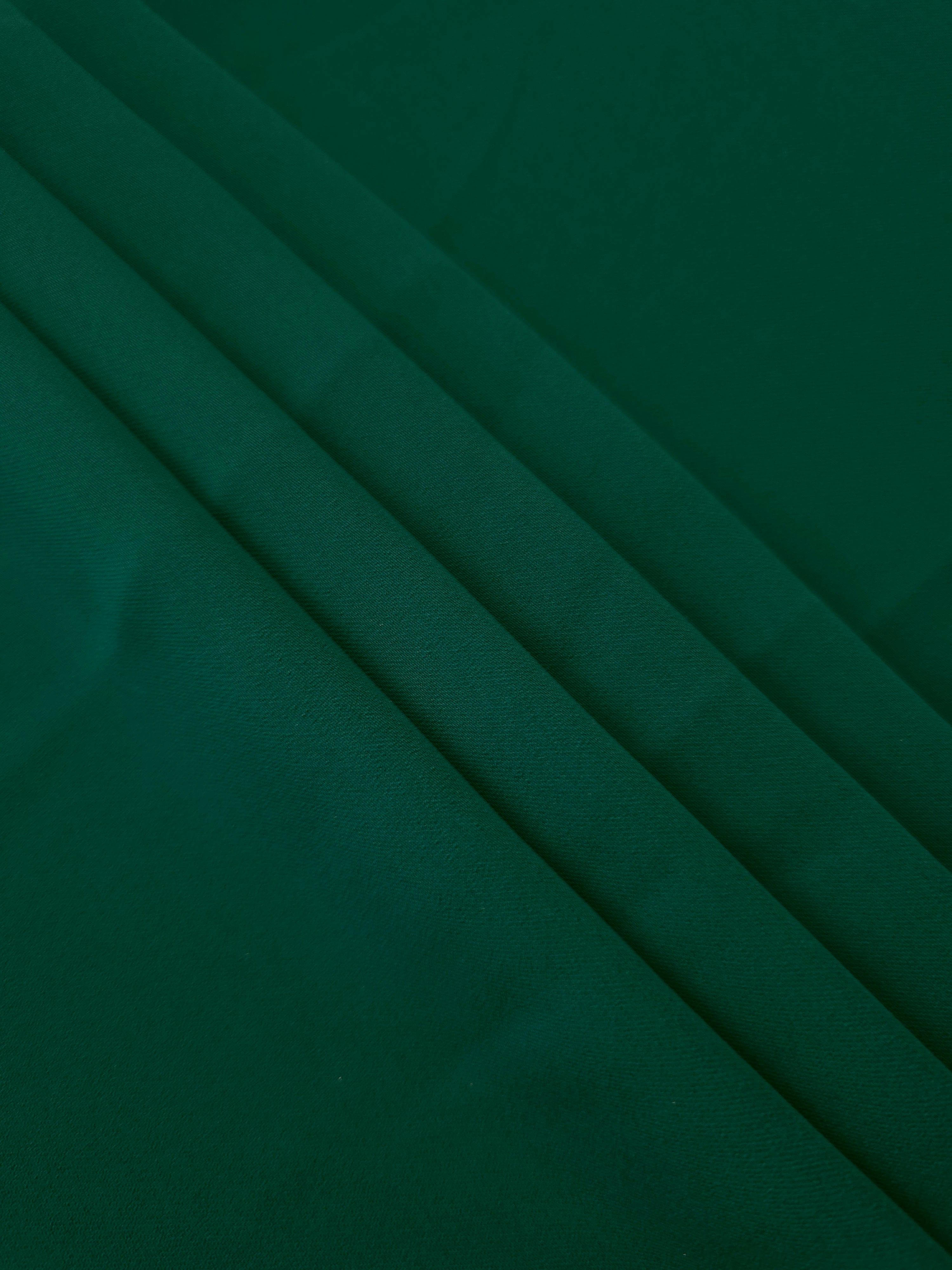 Layered Deep Emerald Green Korean polyester crepe showing gentle mechanical stretch and soft structure for dressmaking