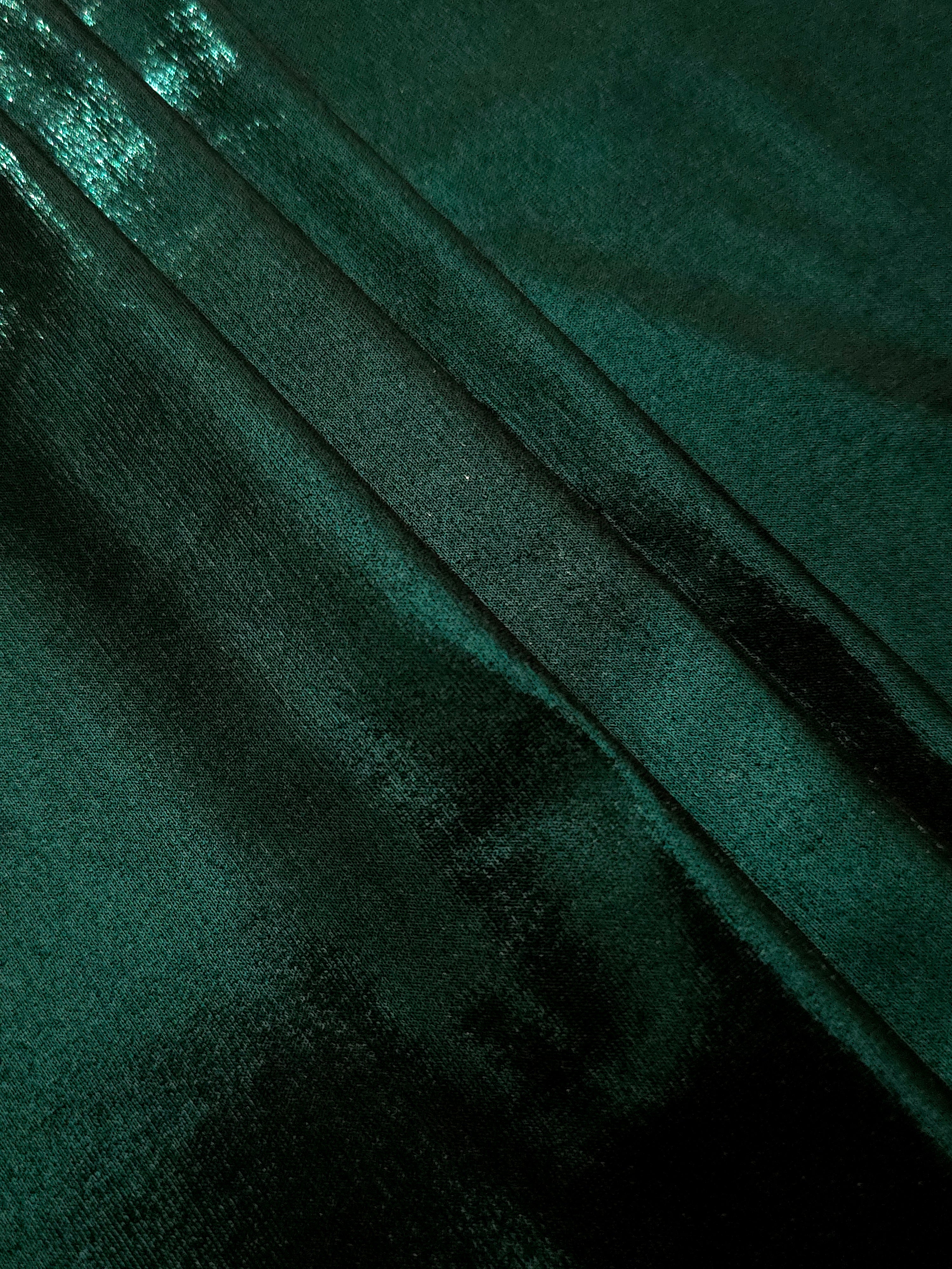 Deep Emerald Green metallic foiled spandex in layered folds, highlighting reflective texture and flexible structure for stage and eveningwear