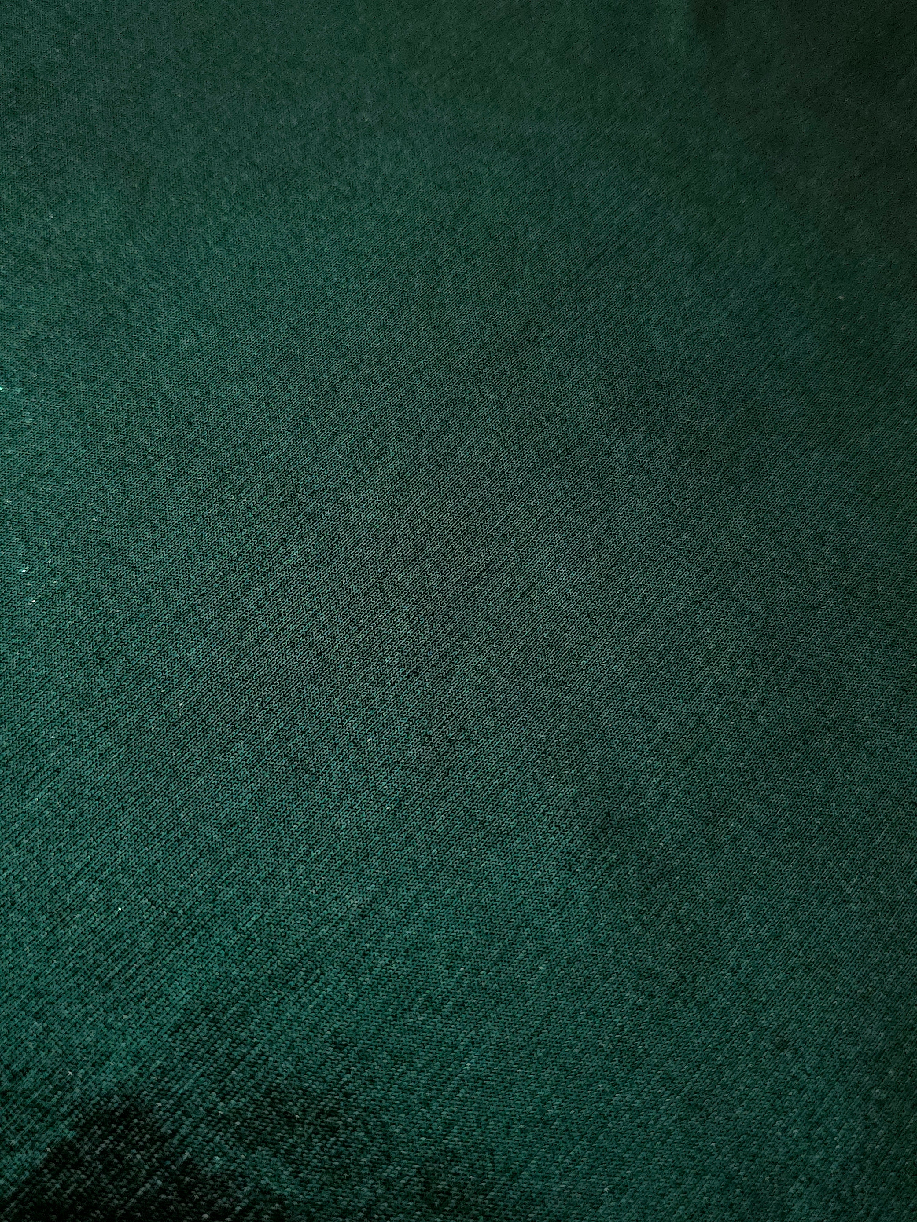 Deep Emerald Green shimmer stretch fabric close-up, revealing metallic foil texture and reflective detail for fashion and costume sewing