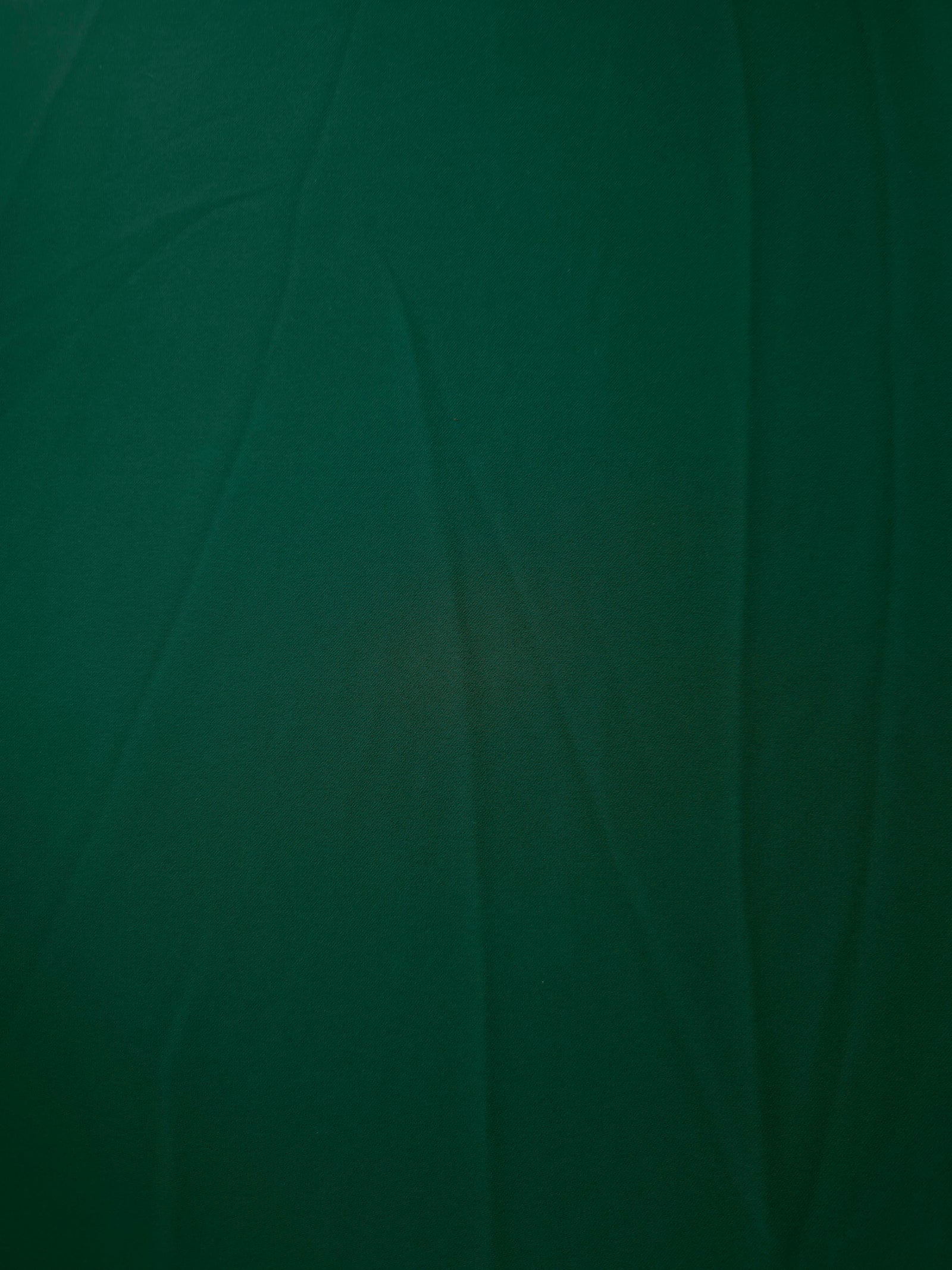 Deep Emerald Green opaque Korean polyester crepe shown flat, 205 GSM smooth woven fabric for dressmaking