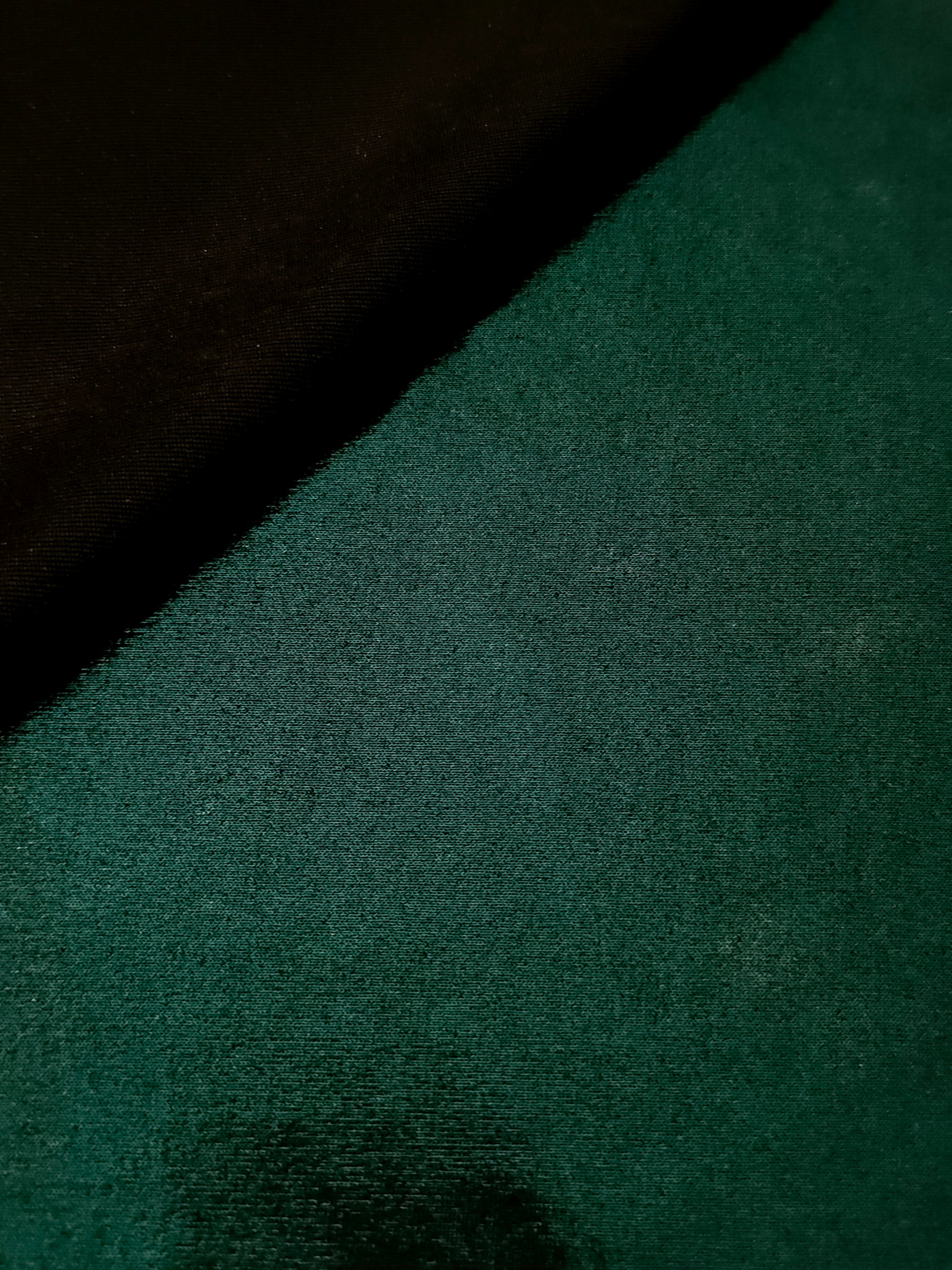 Soft fold of Deep Emerald Green metallic foiled spandex highlighting reflective sheen and supple movement for dresses and stagewear