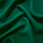 Draped folds of Deep Jade Green polyester crepe showing opaque coverage and fluid movement for garment making