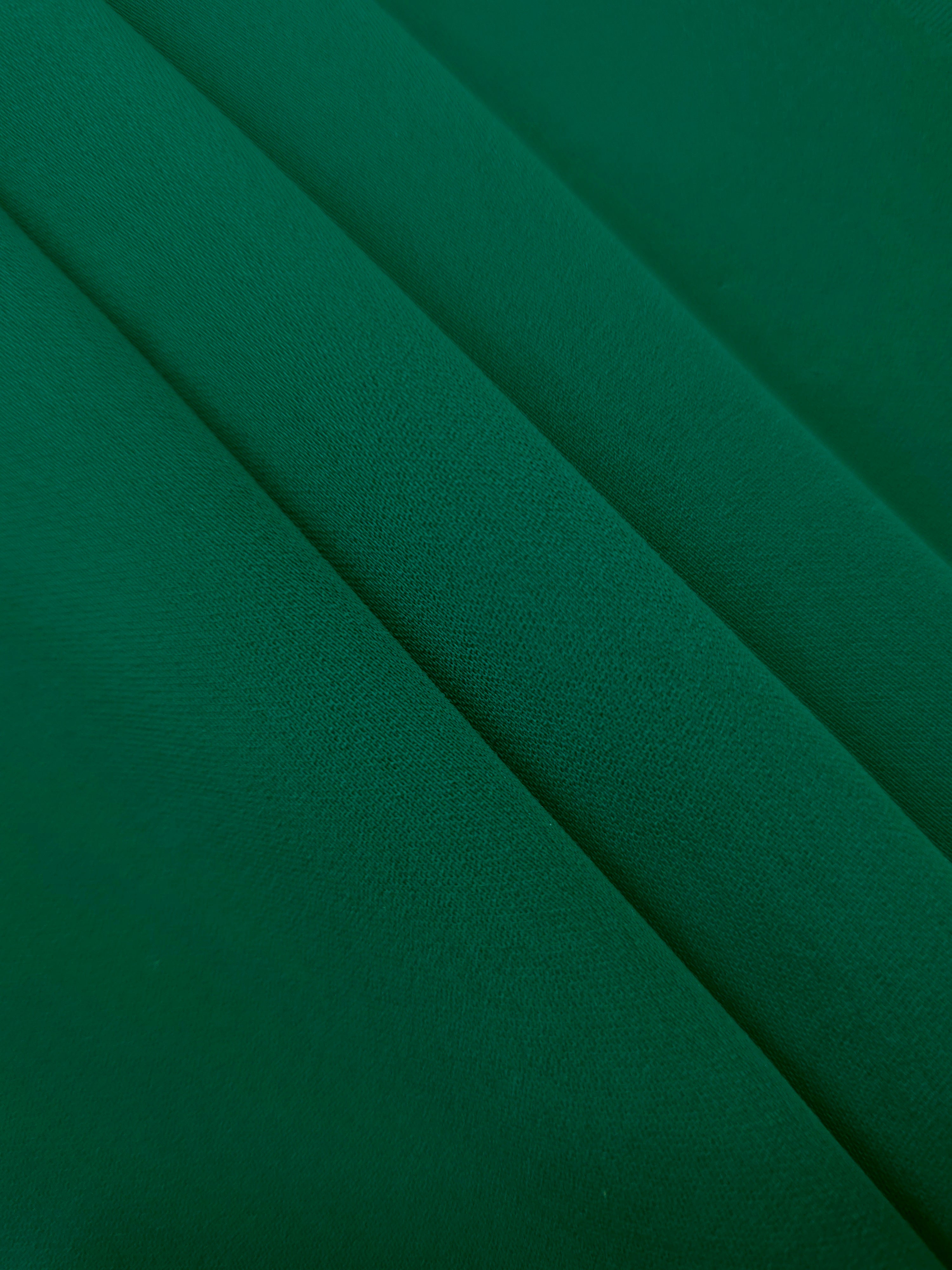 Layered Deep Jade Green Korean polyester crepe showing gentle mechanical stretch and soft structure for dressmaking