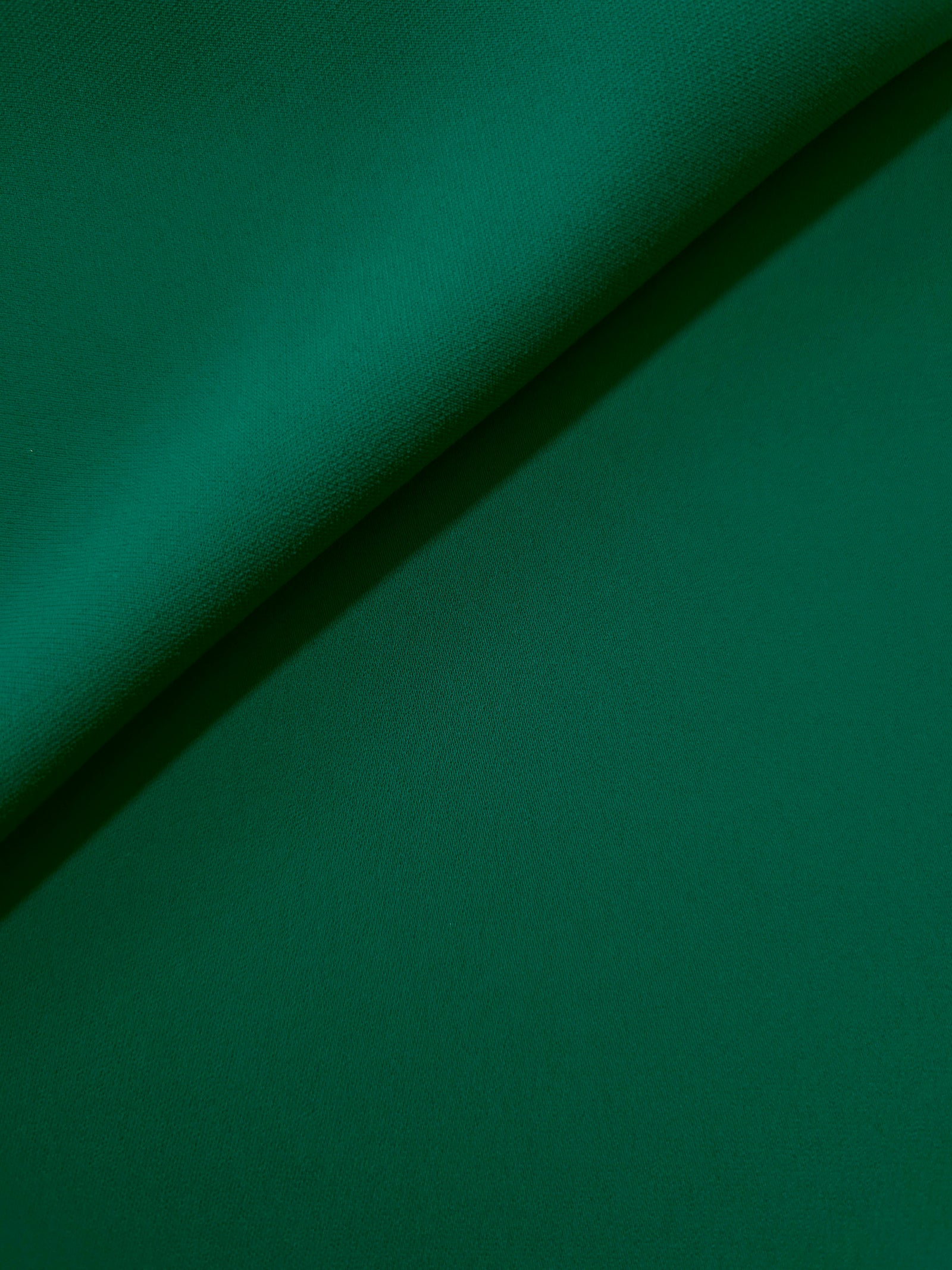 Deep Jade Green opaque Korean polyester crepe in a soft fold, showing flowing drape for garment making
