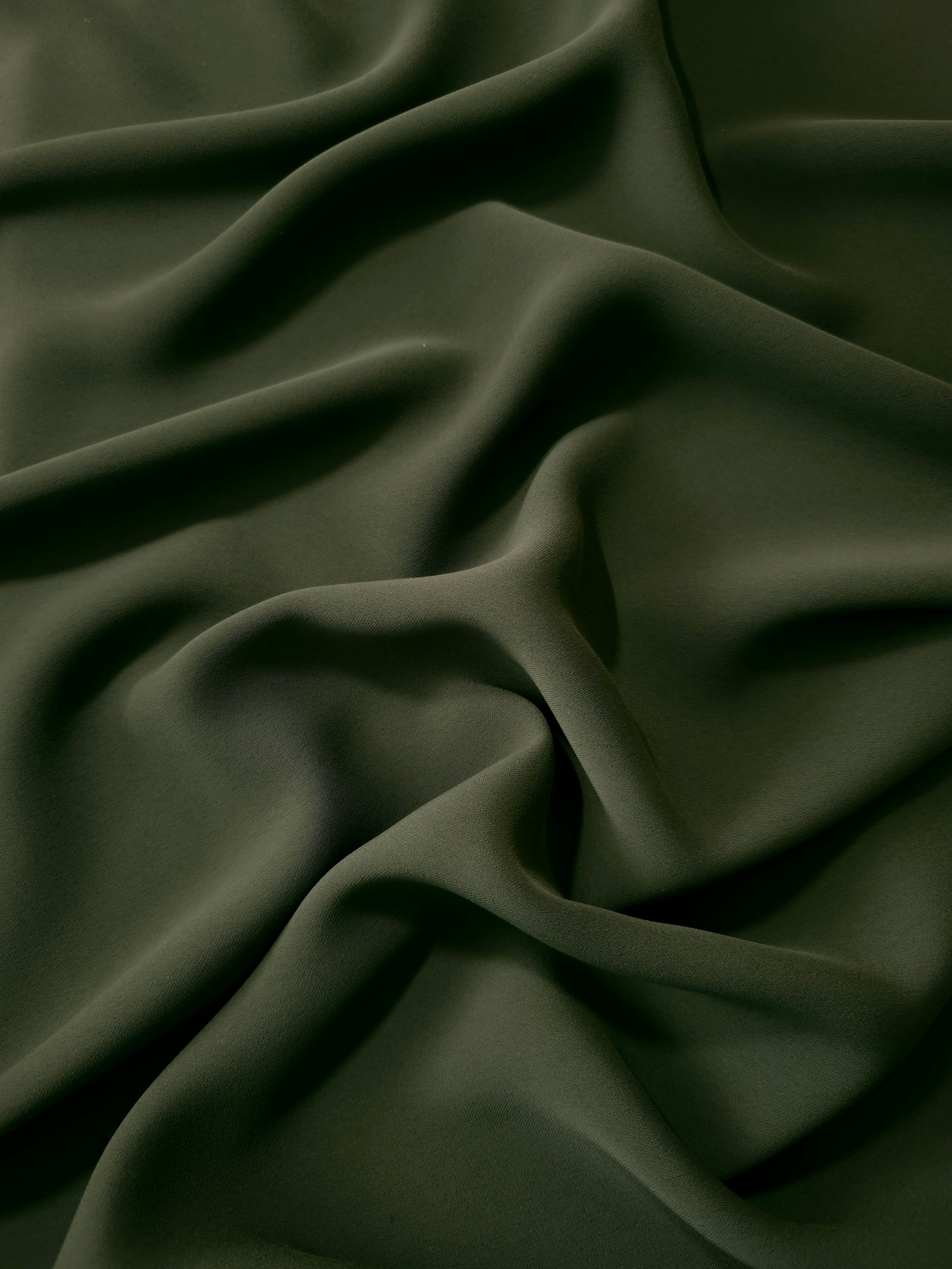 Deep Olive Green Korean polyester dress fabric shown in draped folds for occasionwear, blouses and dresses