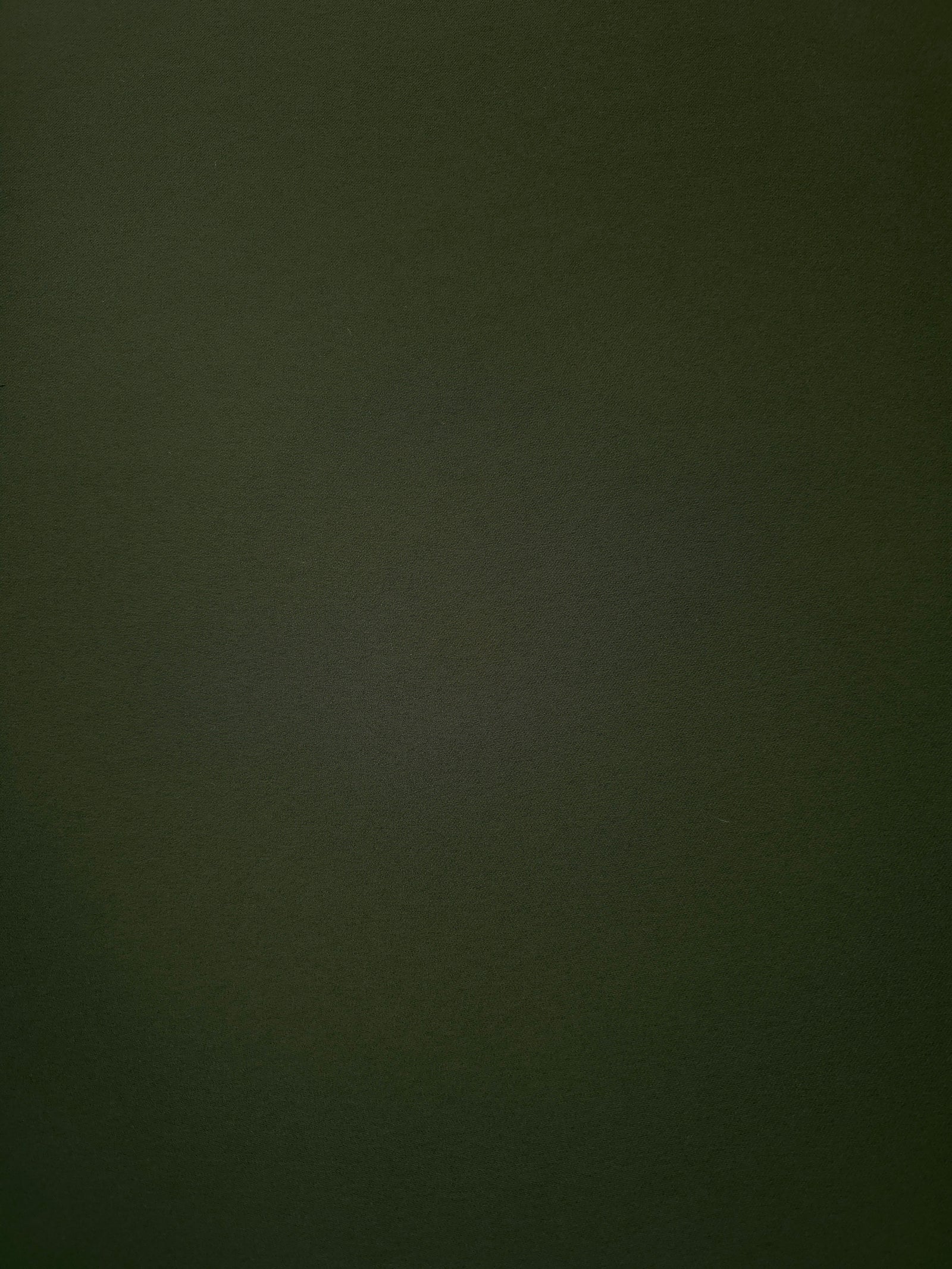 Surface view of Deep Olive Green 205 GSM polyester crepe, opaque Korean dress fabric with a smooth woven finish