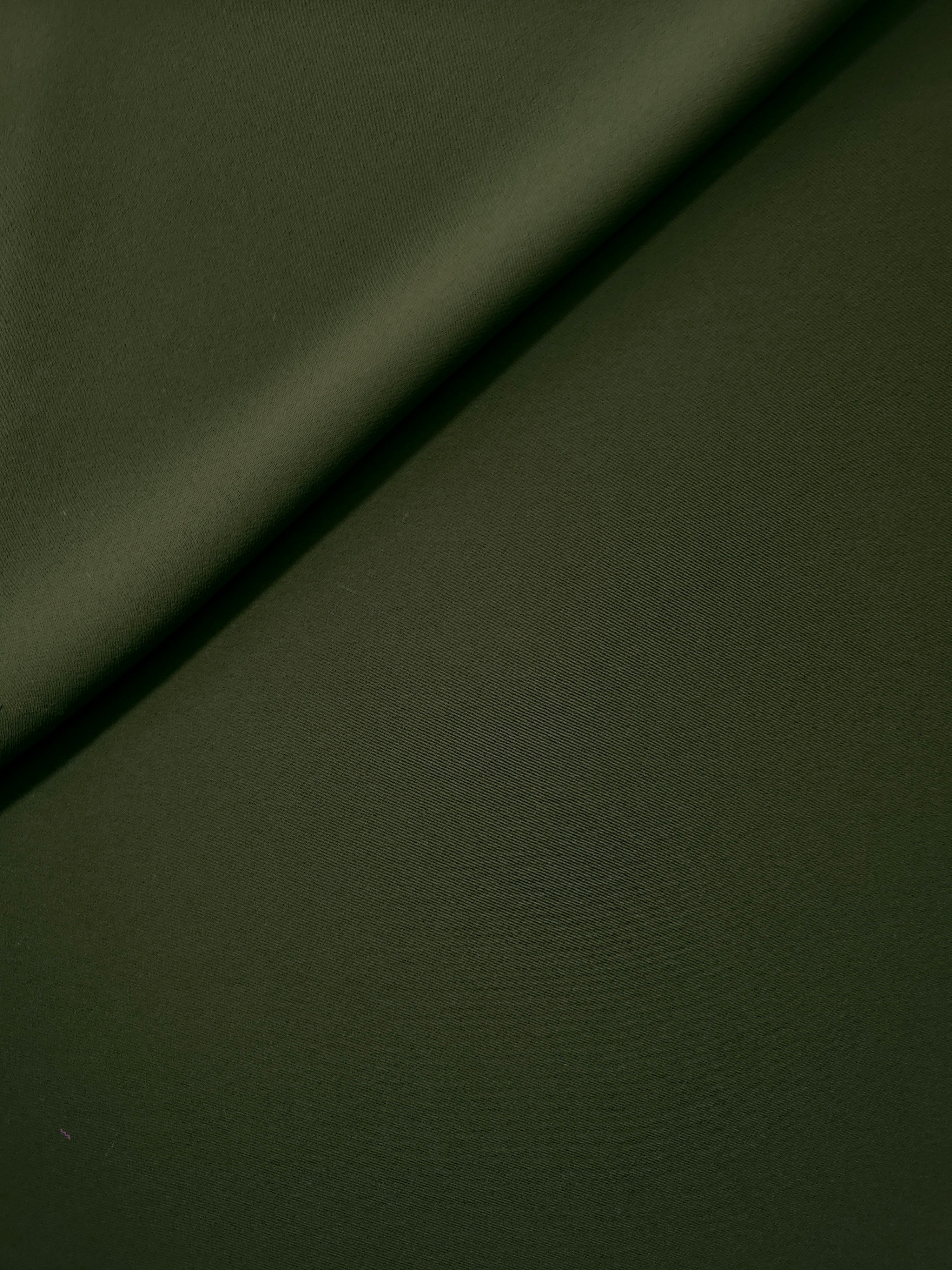 Loose fold of Deep Olive Green polyester crepe showing smooth fluid drape for dresses, skirts and soft tailoring