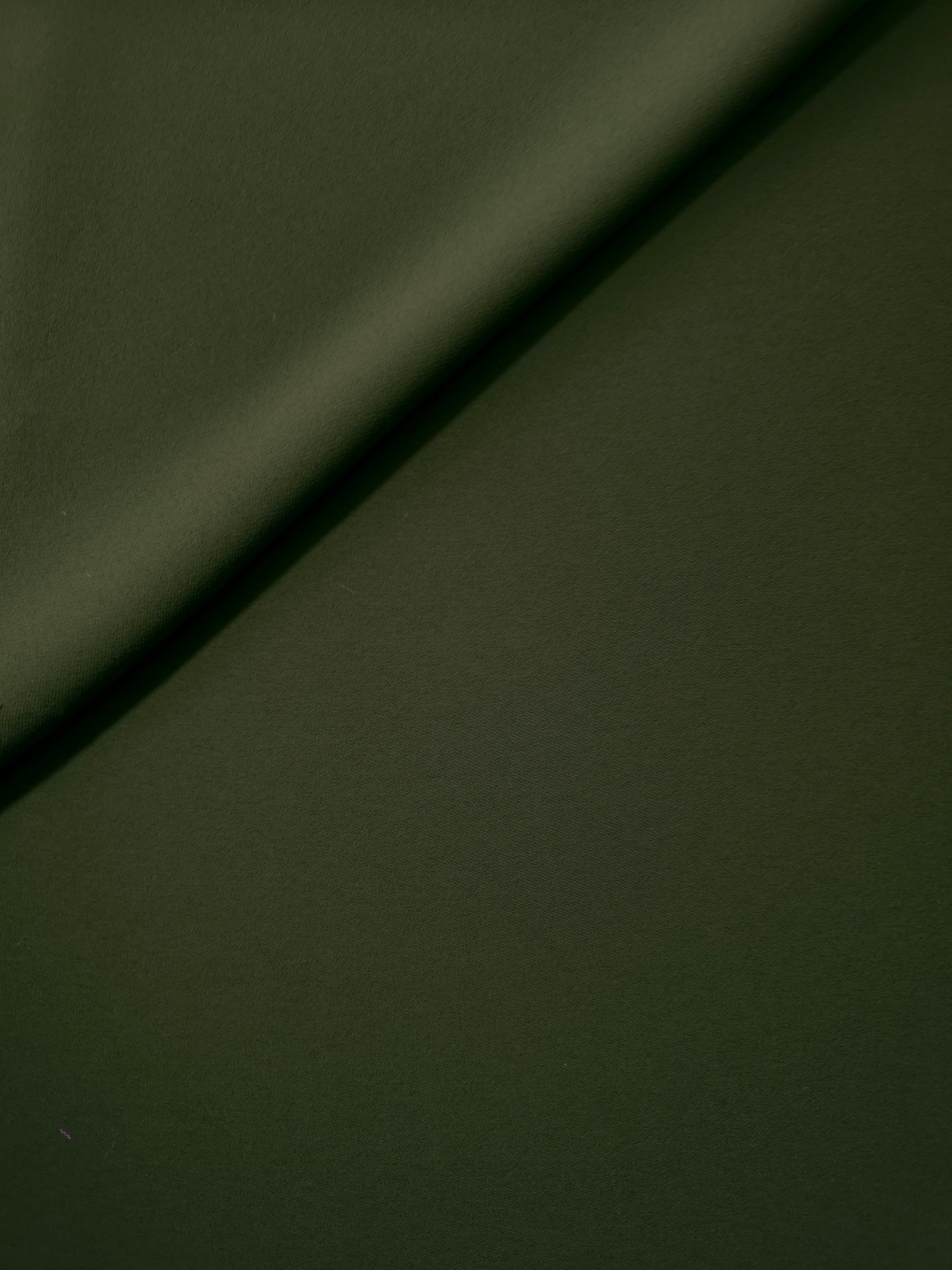 Loose fold of Deep Olive Green polyester crepe showing smooth fluid drape for dresses, skirts and soft tailoring