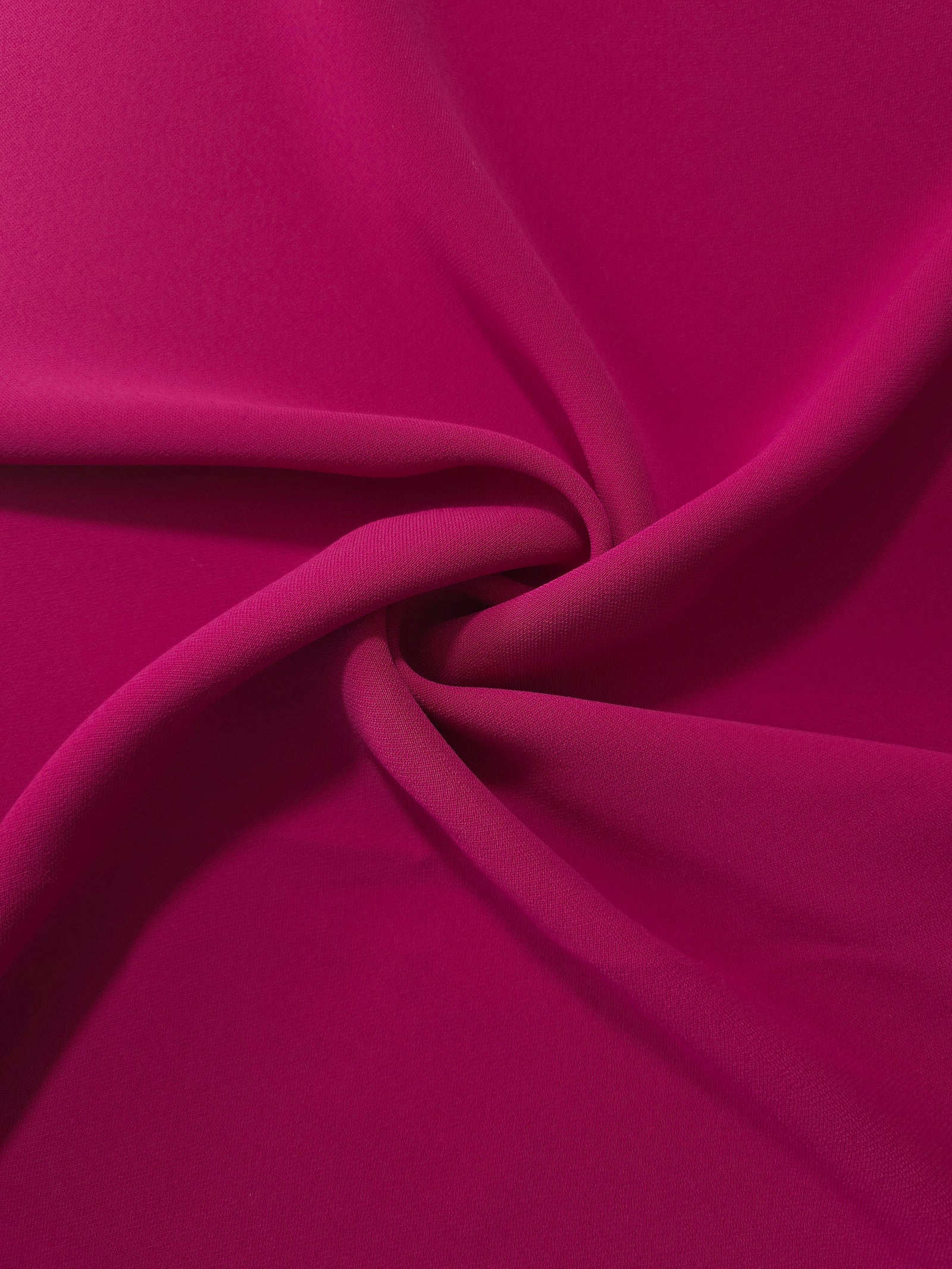 Draped Deep Raspberry Pink Korean polyester crepe showing opaque fluid folds for evening dresses and occasionwear