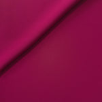 Close-up of Deep Raspberry Pink 100% mechanical polyester crepe showing fine woven texture and a silky-soft hand feel