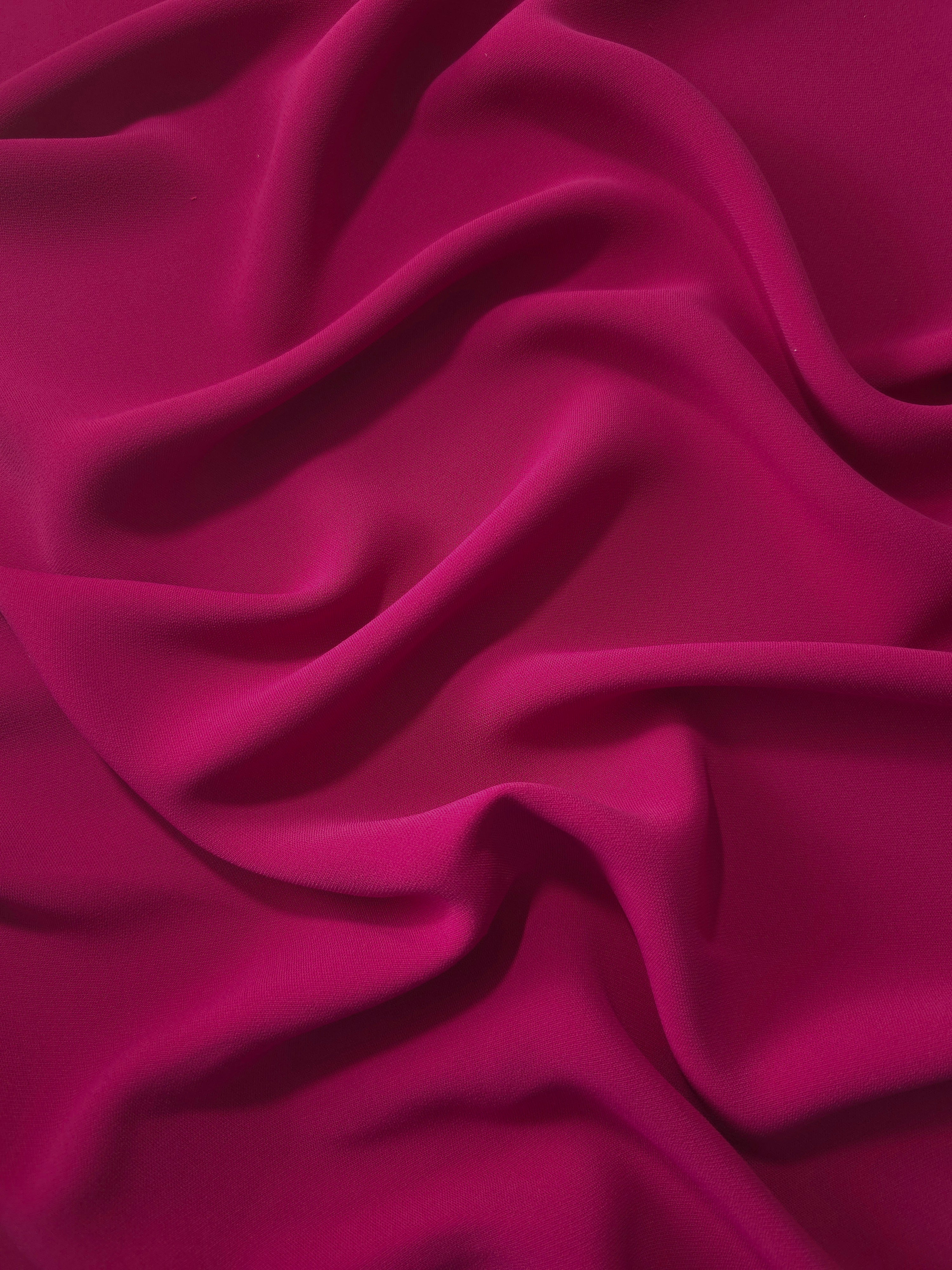 Deep Raspberry Pink Korean polyester crepe in a soft fold, showing fluid drape for blouses and flowing dresses