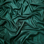 Draped Deep Teal Green metallic foiled spandex showing reflective folds and flexible flow for dresses, stagewear and occasion looks