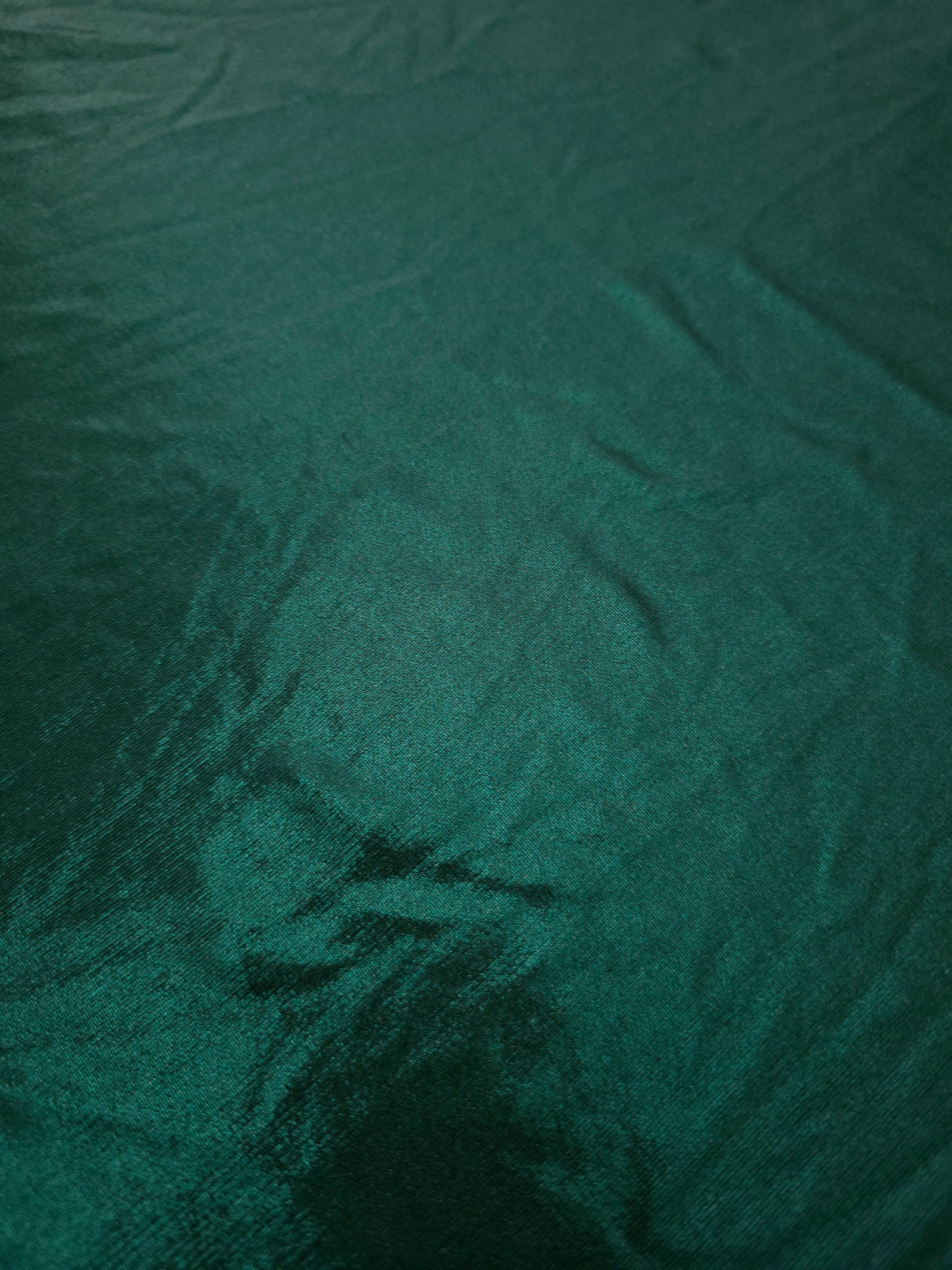 Close-up of Deep Teal Green metallic foiled spandex showing reflective surface texture and the detailed shimmer finish