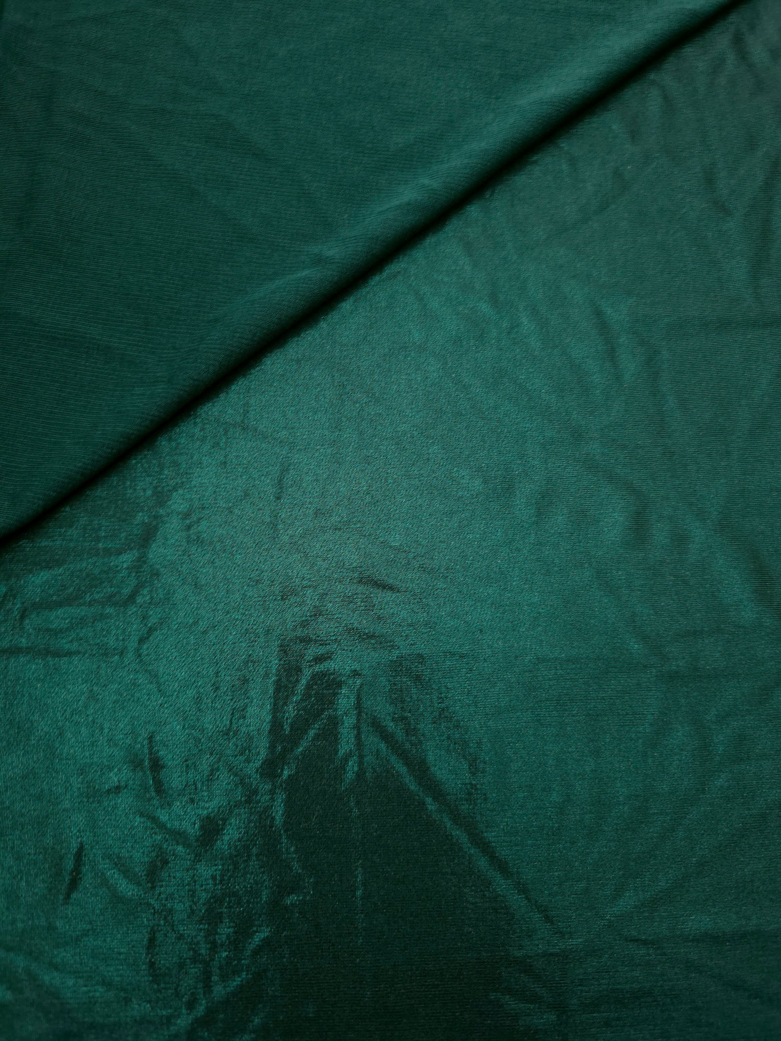 Deep Teal Green shimmer spandex in a soft fold, showing metallic foil sheen and flexible drape for tops, skirts and costumes