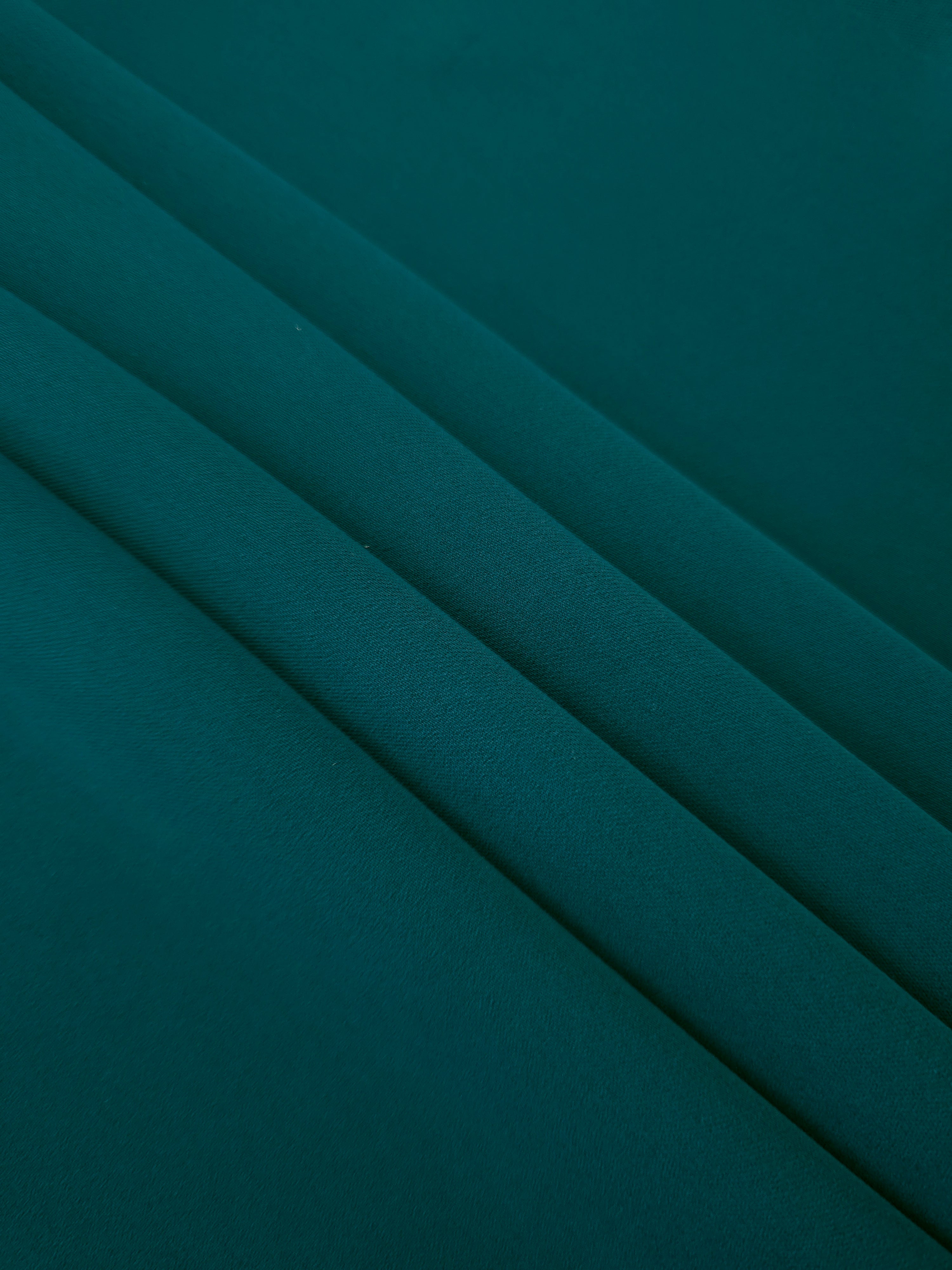 Layered Deep Teal Korean polyester crepe showing gentle mechanical stretch and soft structure for dressmaking